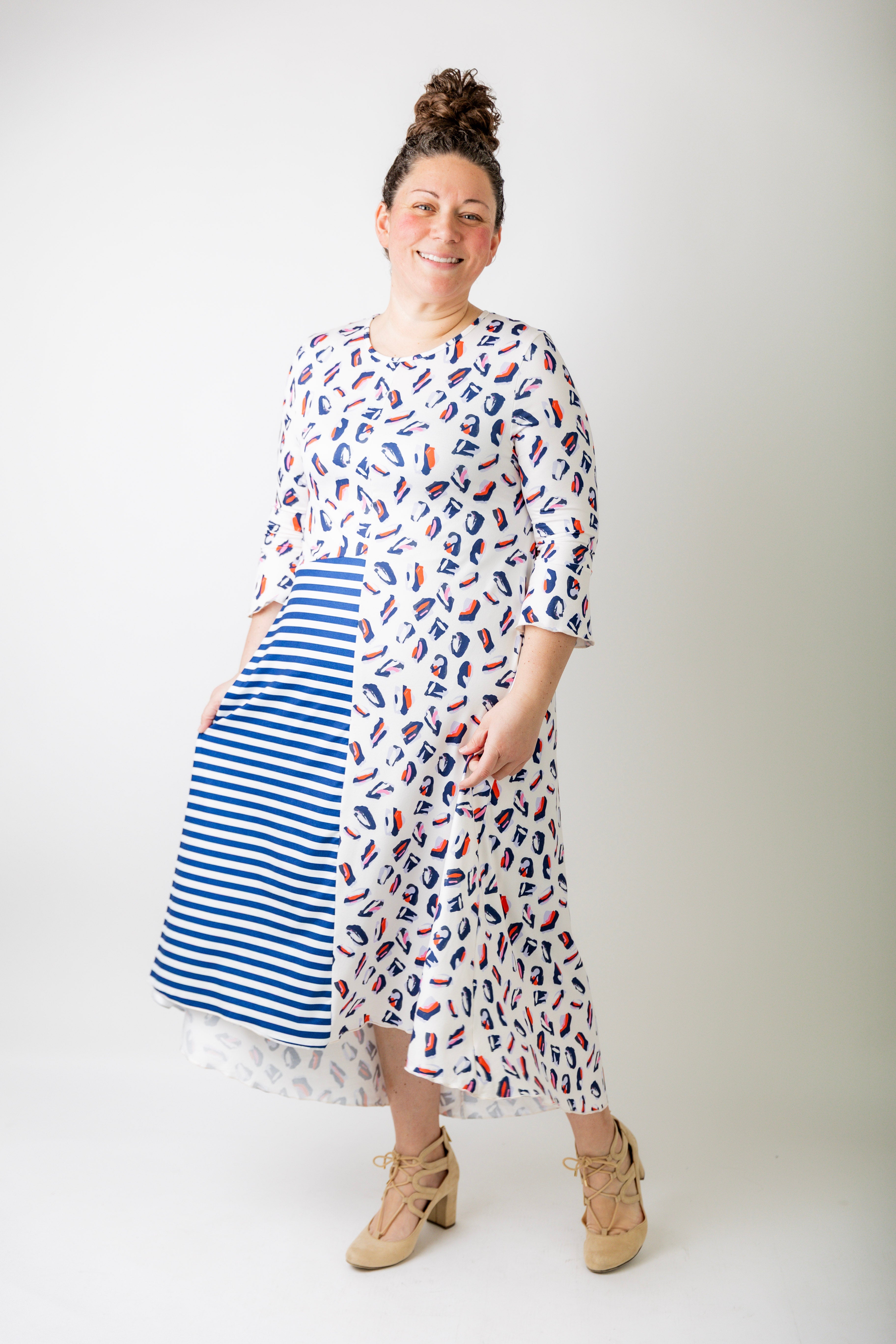 Woman wearing a modest, midi dress that is also available in plus sizes and is maternity friendly. The dress features blue stripes as well as a fun leopard print.