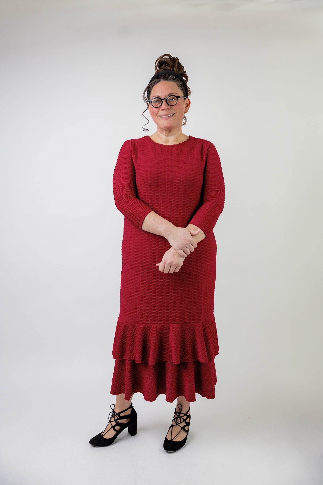 Woman wearing a red ruffled layering dress that is available in plus sizes XL to 3X.