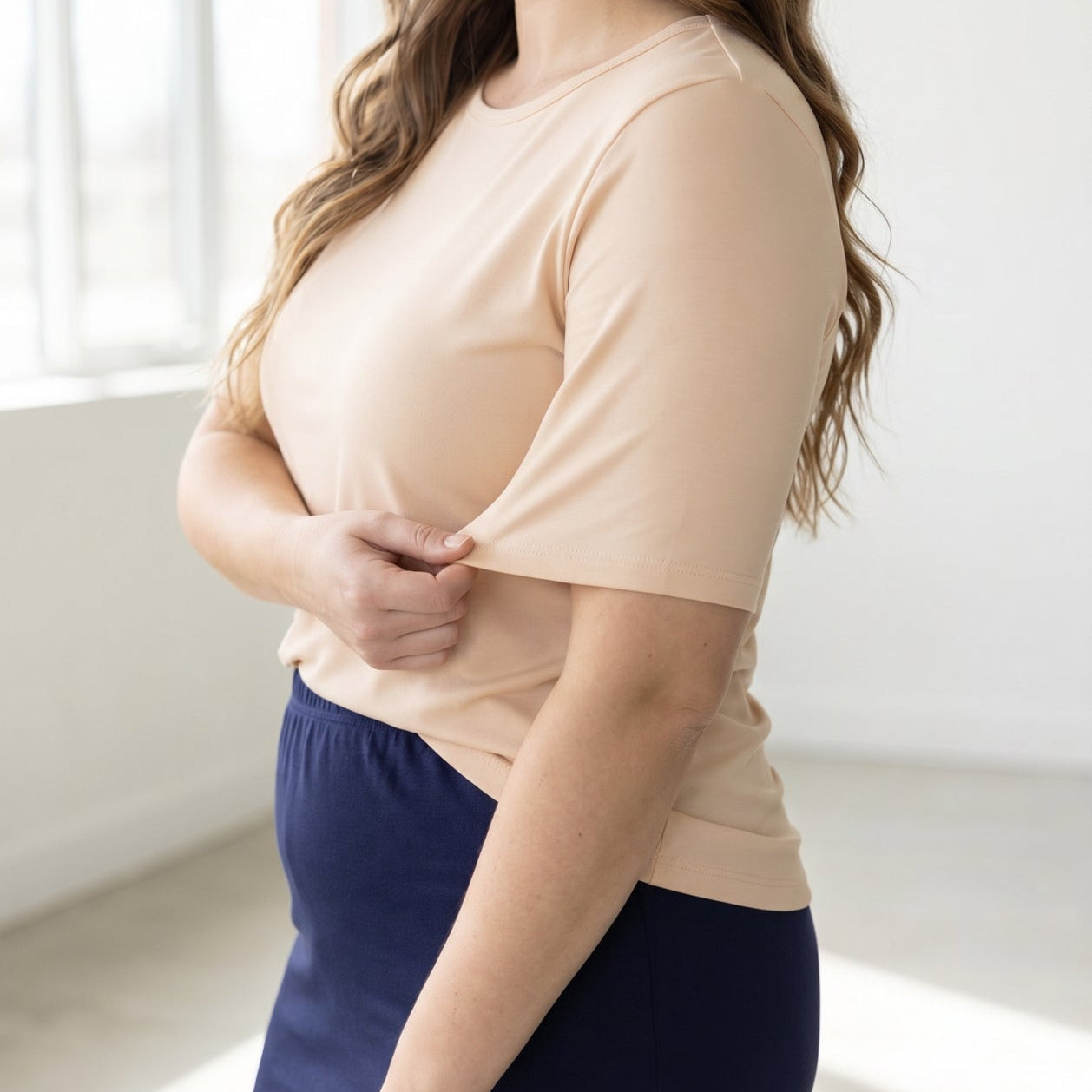 A women wearing a half sleeve tee in a neutral color.