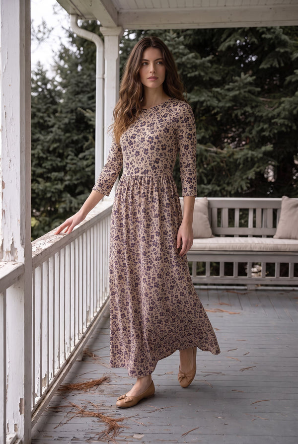 Nuggles® Cleo Maxi Dress in Tigerlily, full length mid-stride on a porch with one hand on the railing