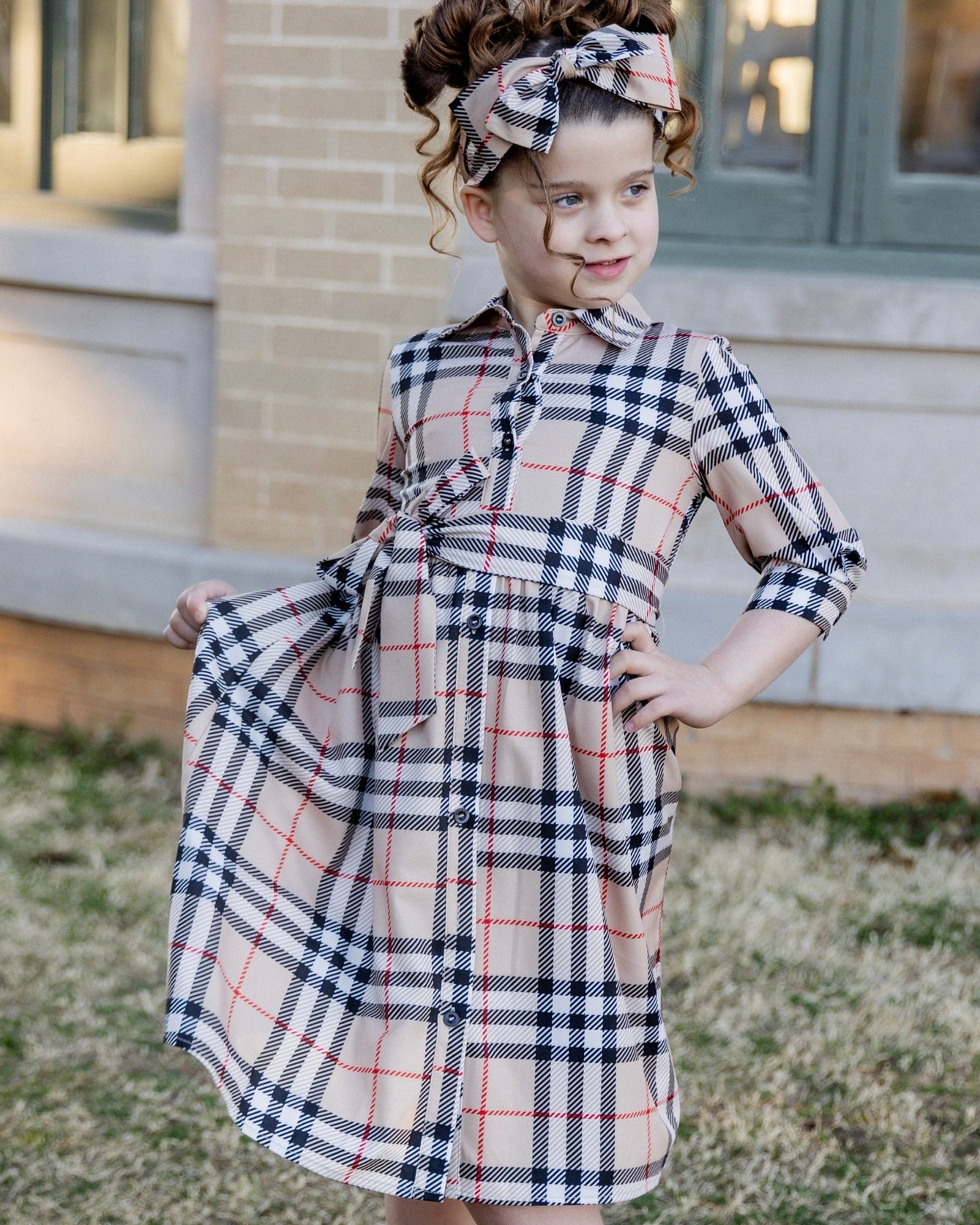 Model wearing the Nuggles® Girls' Rachel Dress and matching Headband in Sand Plaid
