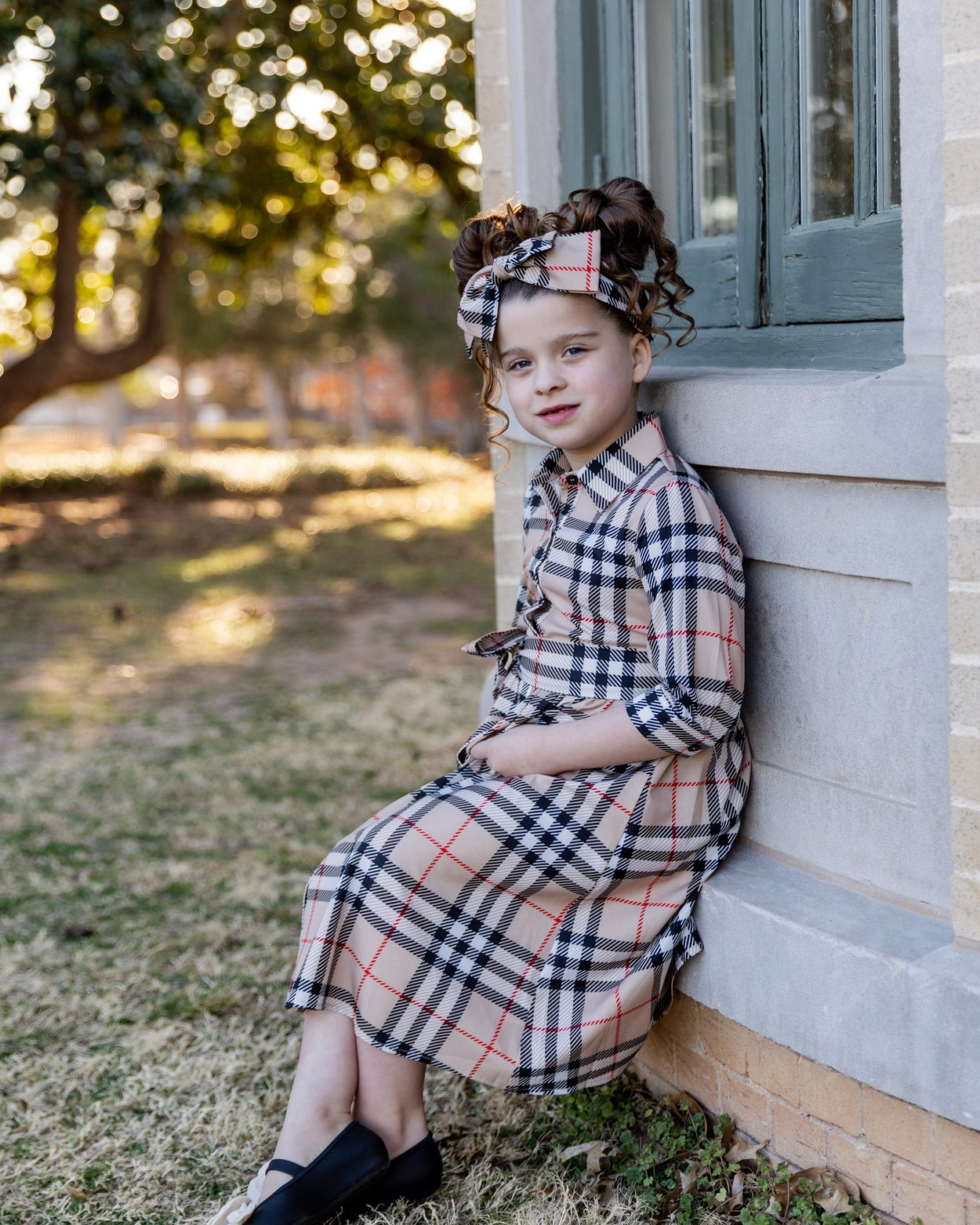 Model wearing the Nuggles® Girls' Rachel Dress in Sand Plaid