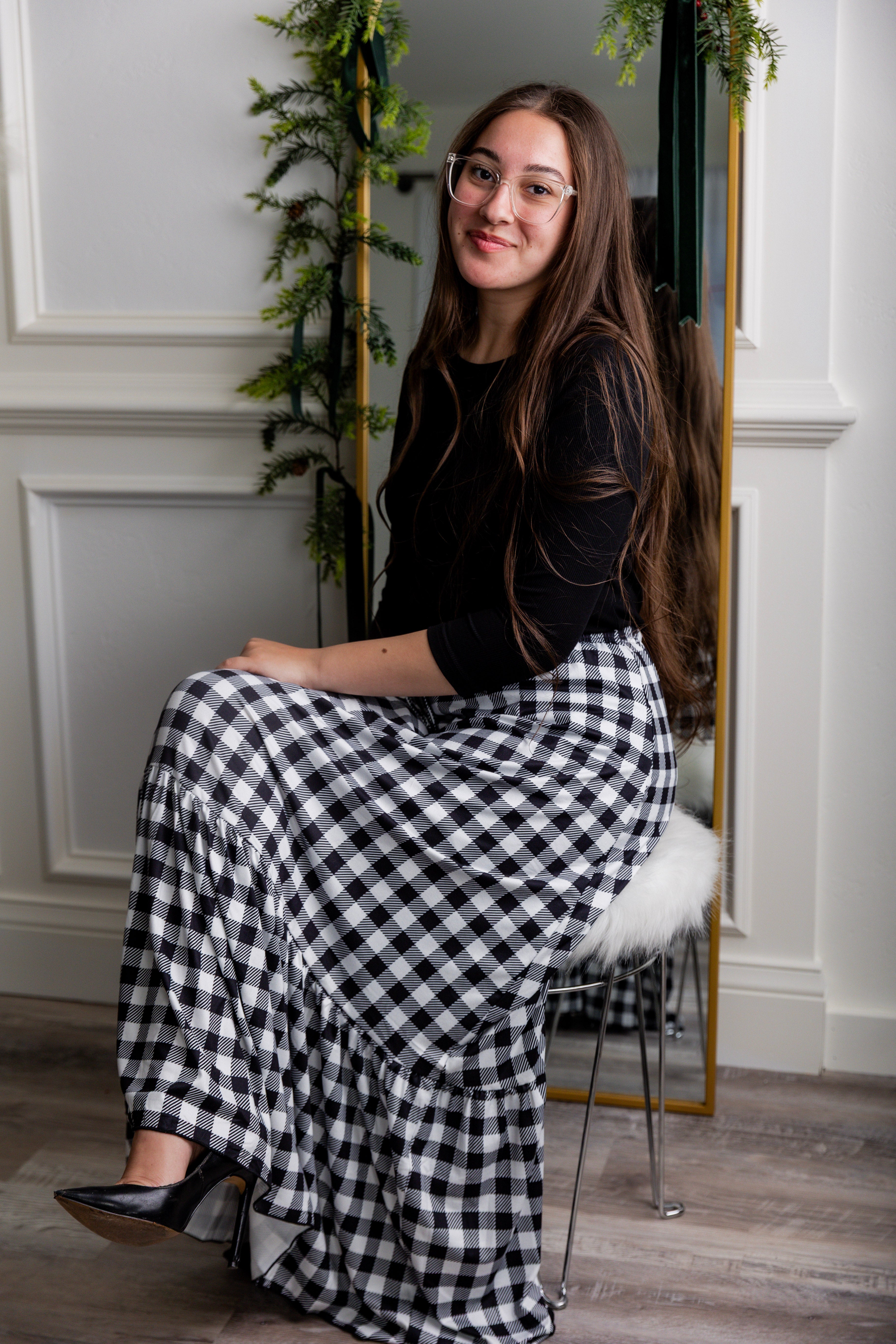 Model wearing the Nuggles® Sage Skirt in black and white gingham, featuring a tiered ruffle hem and drawstring waist.