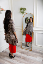 Leopard print modest tunic top for women – Nuggles® Rose Top with swing fit and ruffle hem, paired with red skirt.