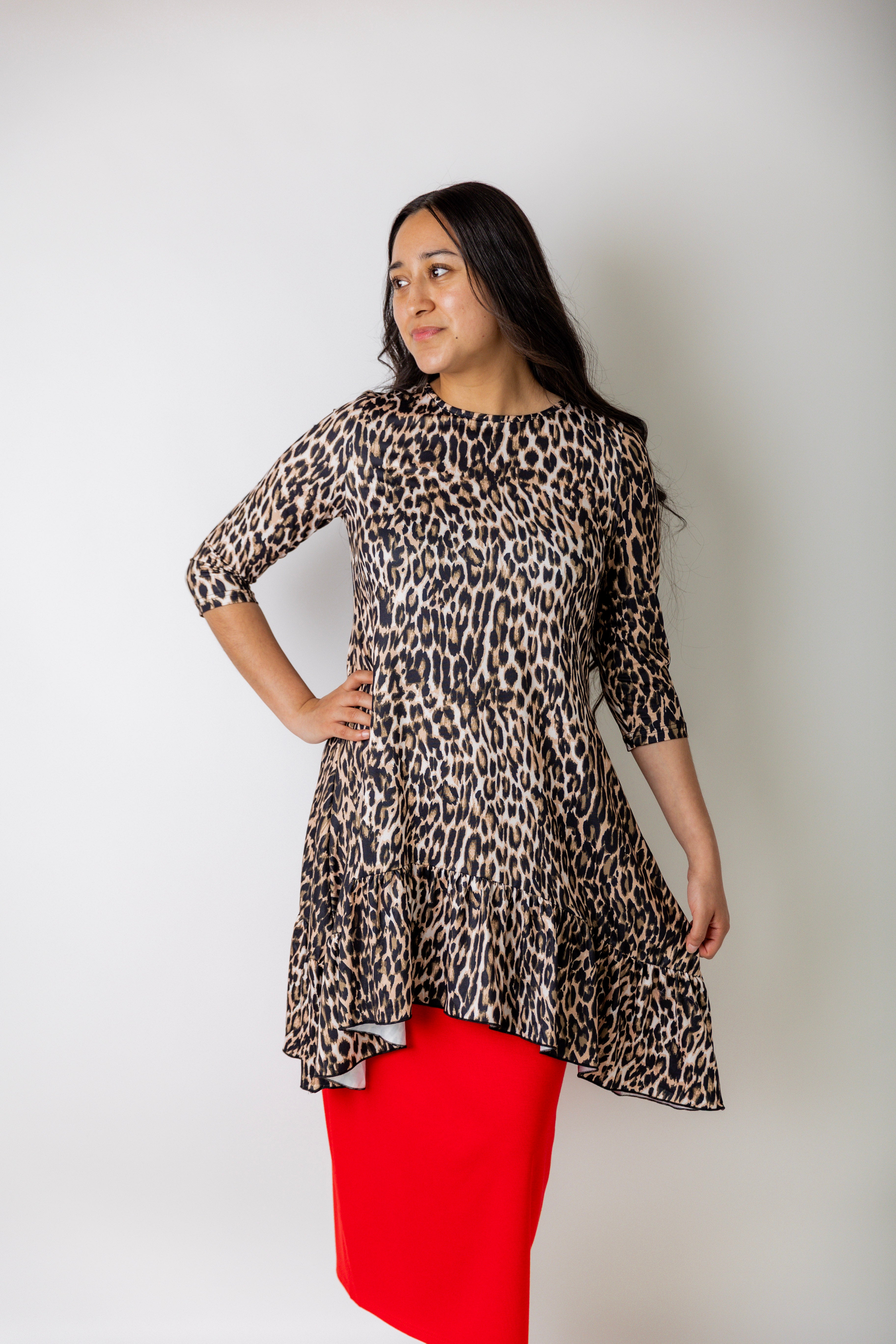 Leopard print modest tunic top for women – Nuggles® Rose Top with swing fit and ruffle hem, paired with red skirt.