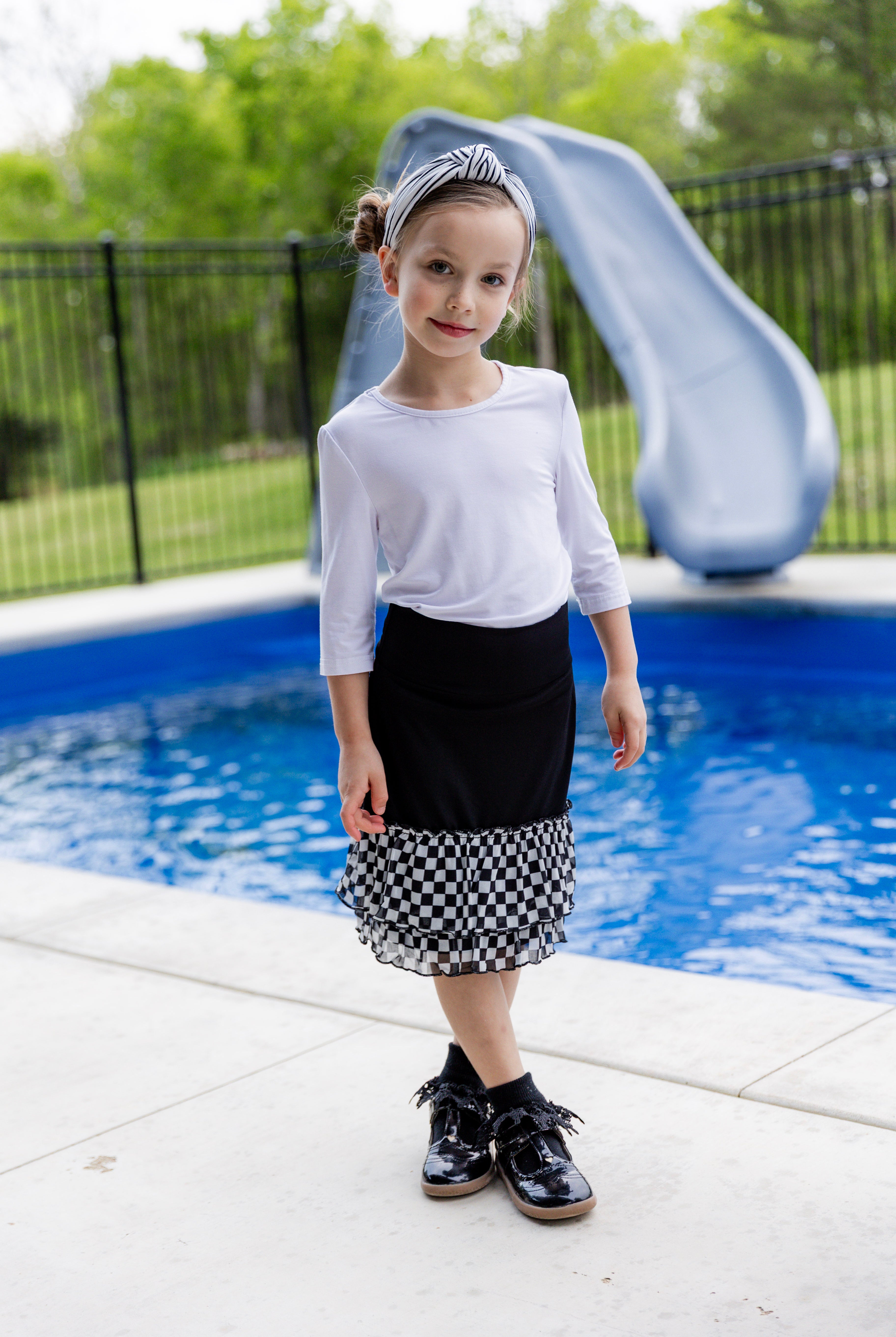 Modest girls’ ruffle slip with wide no-elastic waistband, perfect for layering under dresses and skirts.