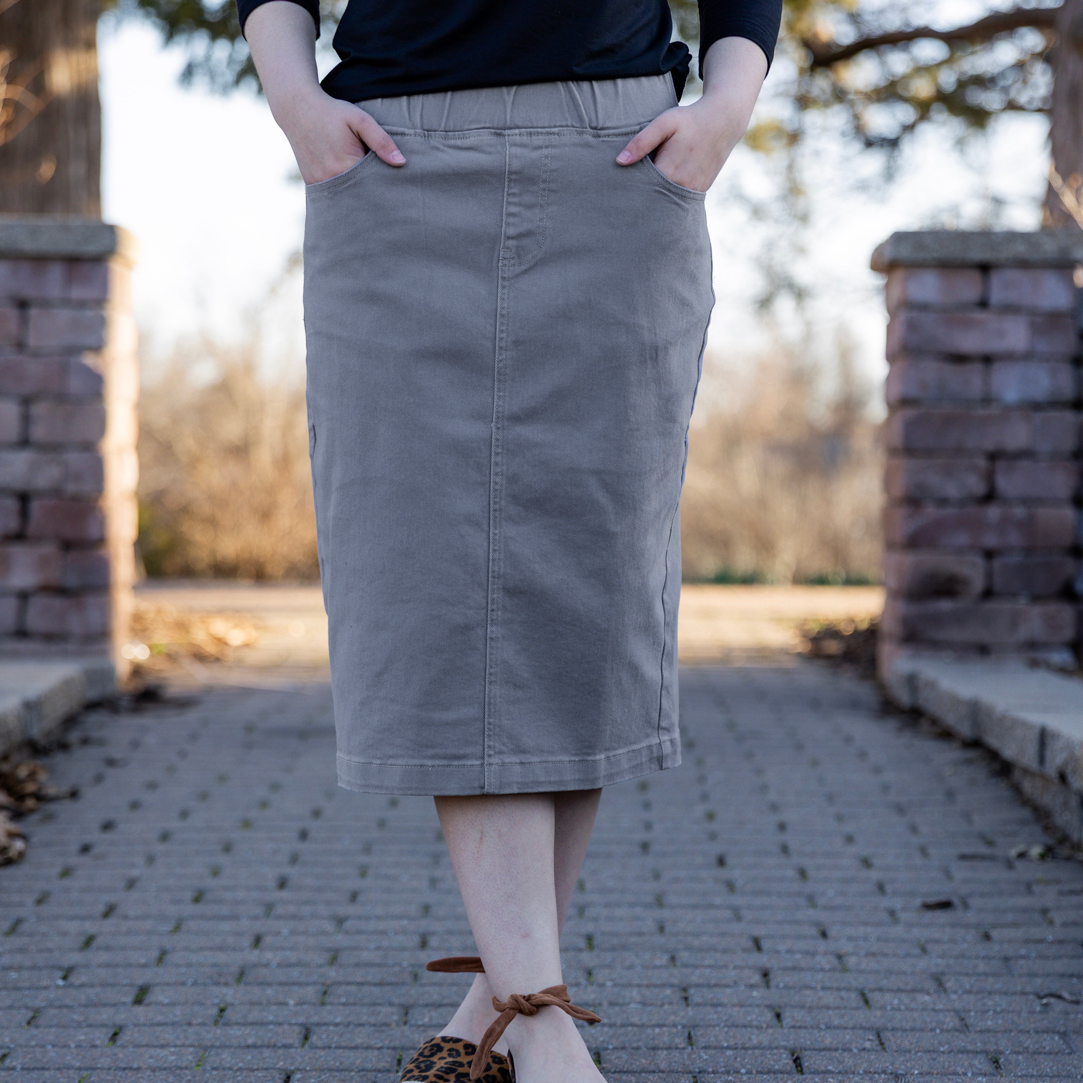 Nuggles denim midi skirt with soft stretch fabric, wide elastic waistband, modest length, and functional pockets. Available in 27", 31", and 34" lengths.