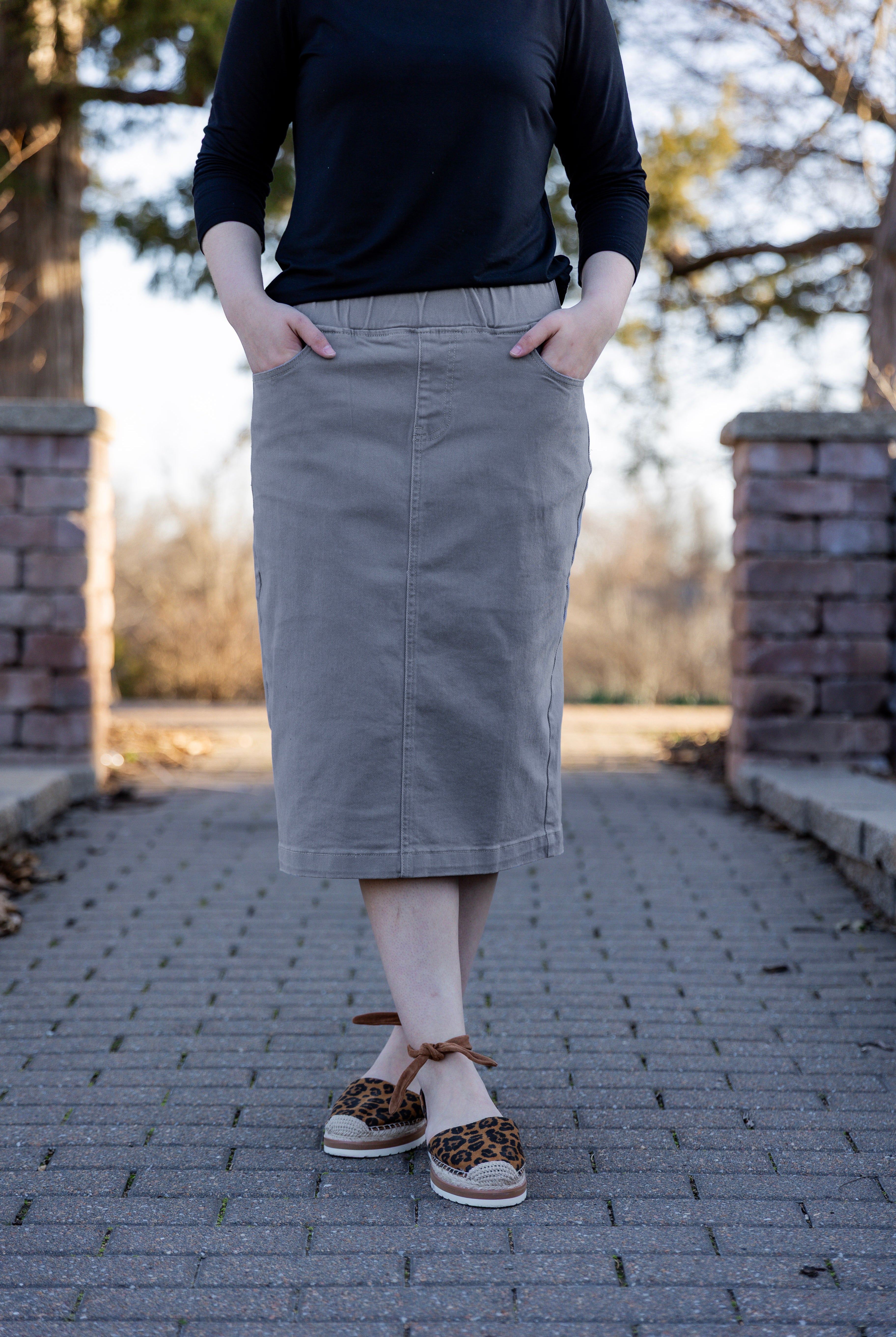 Nuggles® denim midi skirt with soft stretch fabric, wide elastic waistband, modest length, and functional pockets. Available in 27", 31", and 34" lengths.
