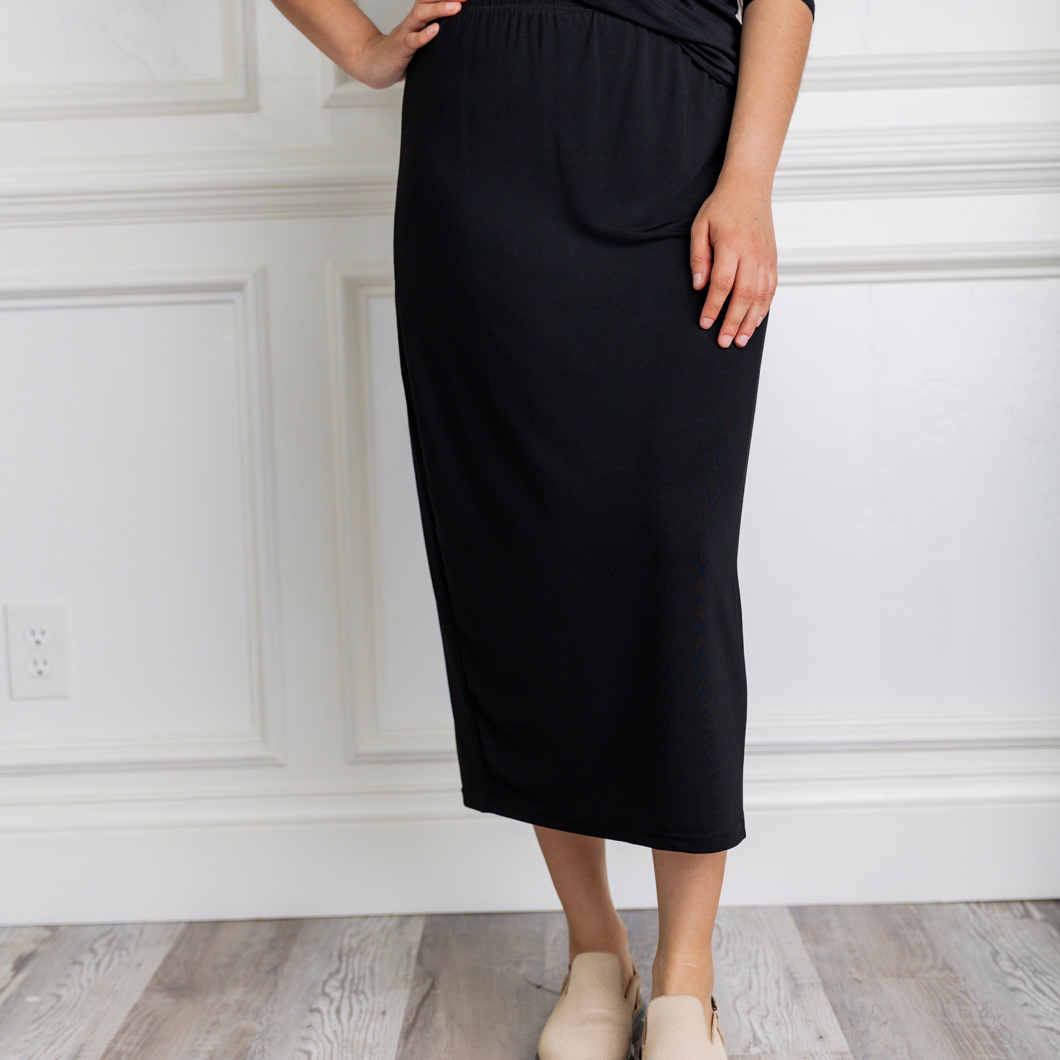 Model wearing a 31-inch classic lightweight midi skirt with an elastic waistband, styled modestly for everyday or church wear.