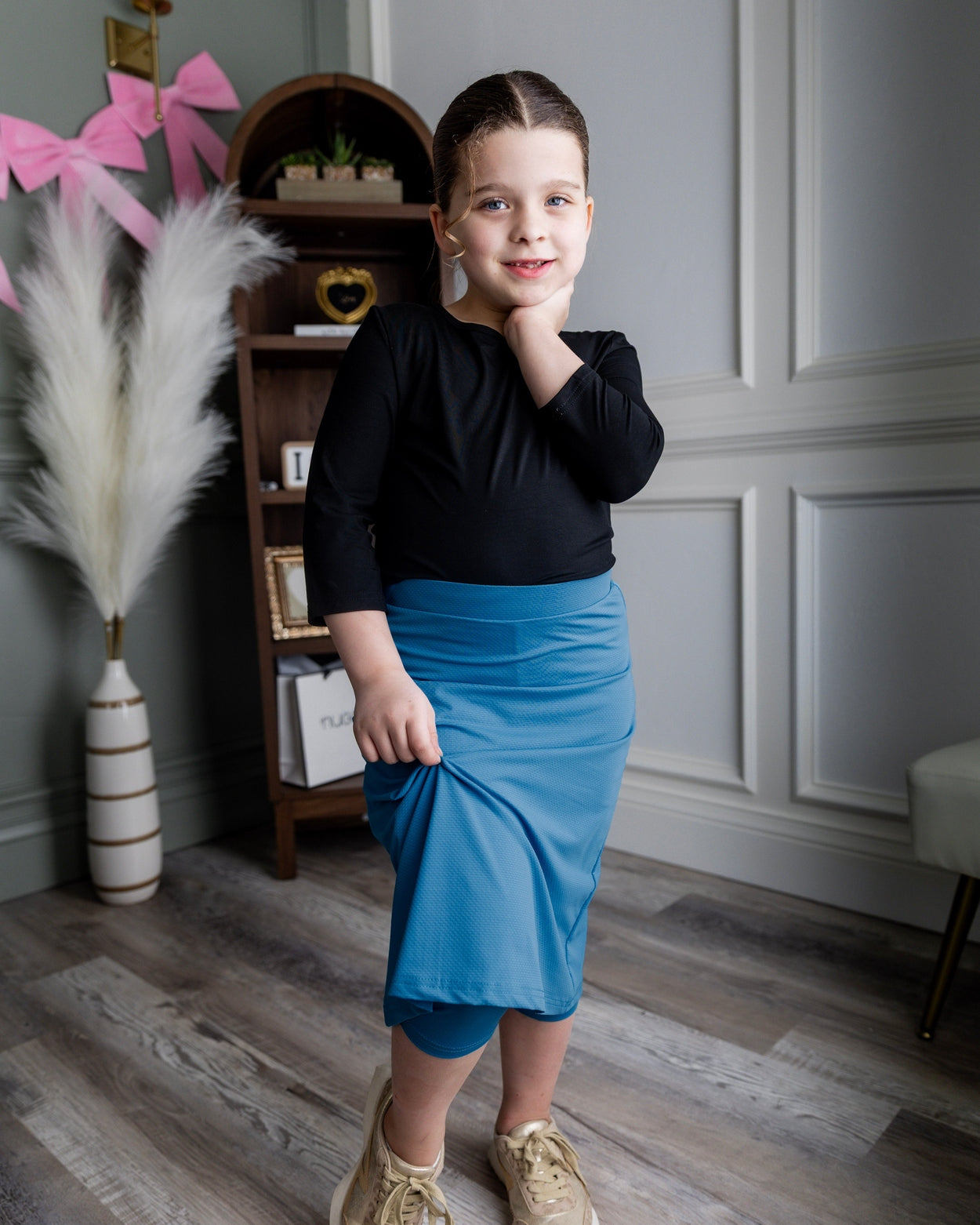 Model wearing Nuggles® Girls' All-Sport Skirt in Turquoise