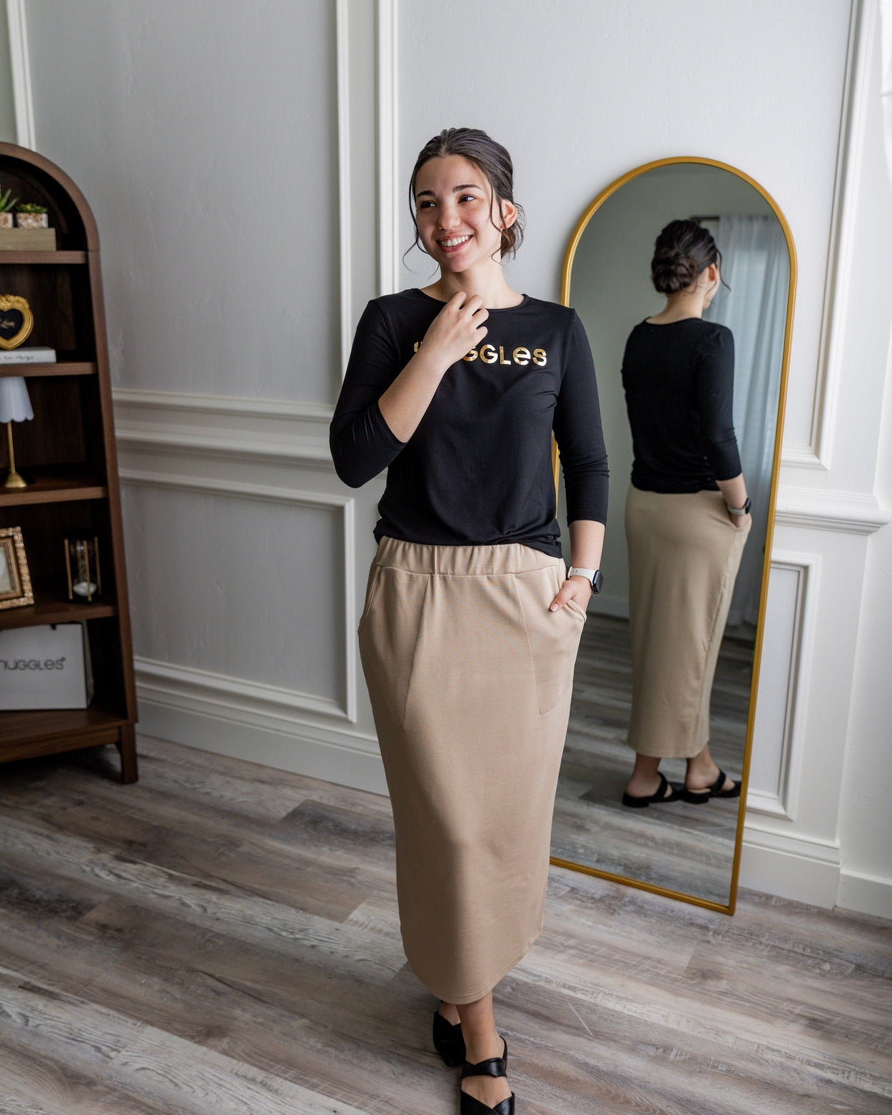 A modest midi length knit skirt in a khaki color featuring two front pockets and a large elastic waistband.