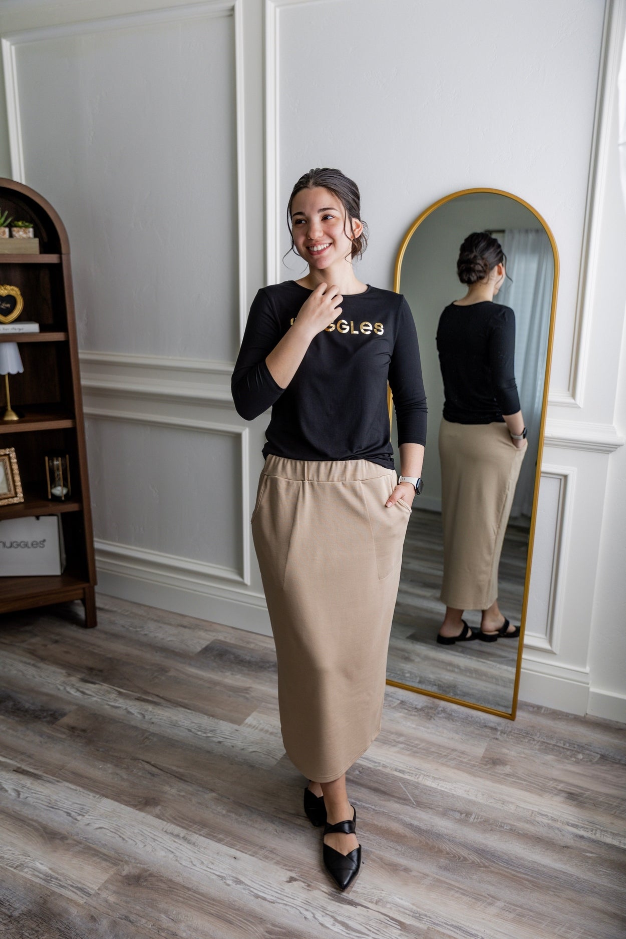 A modest midi length knit skirt in a khaki color featuring two front pockets and a large elastic waistband.