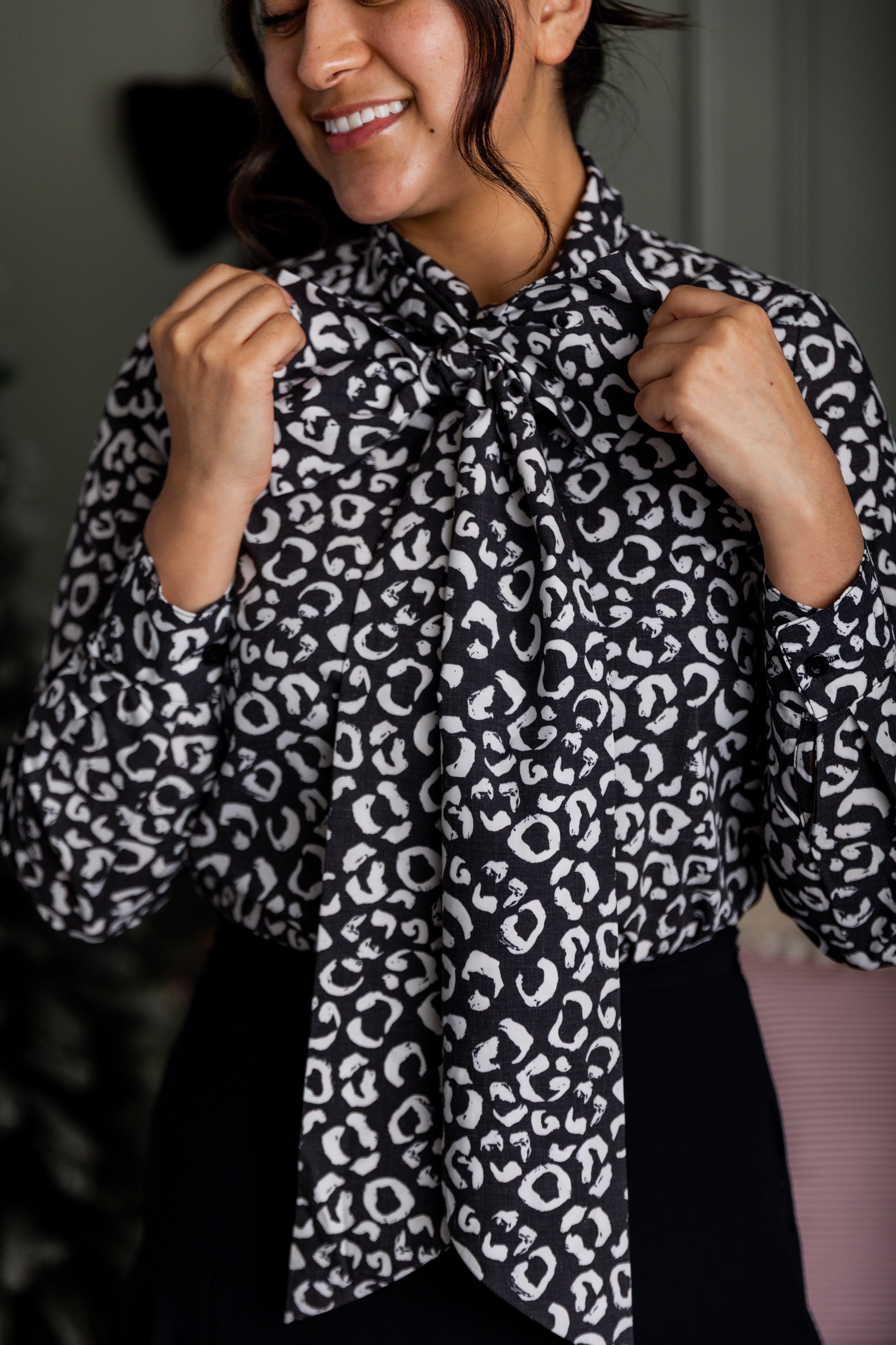 Model wearing Nuggles® Felicity top with large bow tie neckline, modest women's blouse.