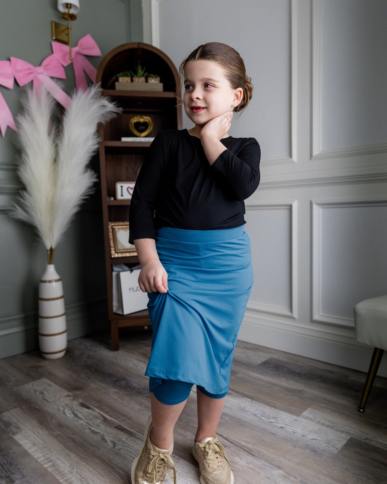 Model wearing Nuggles® Girls' All-Sport Skirt in Turquoise
