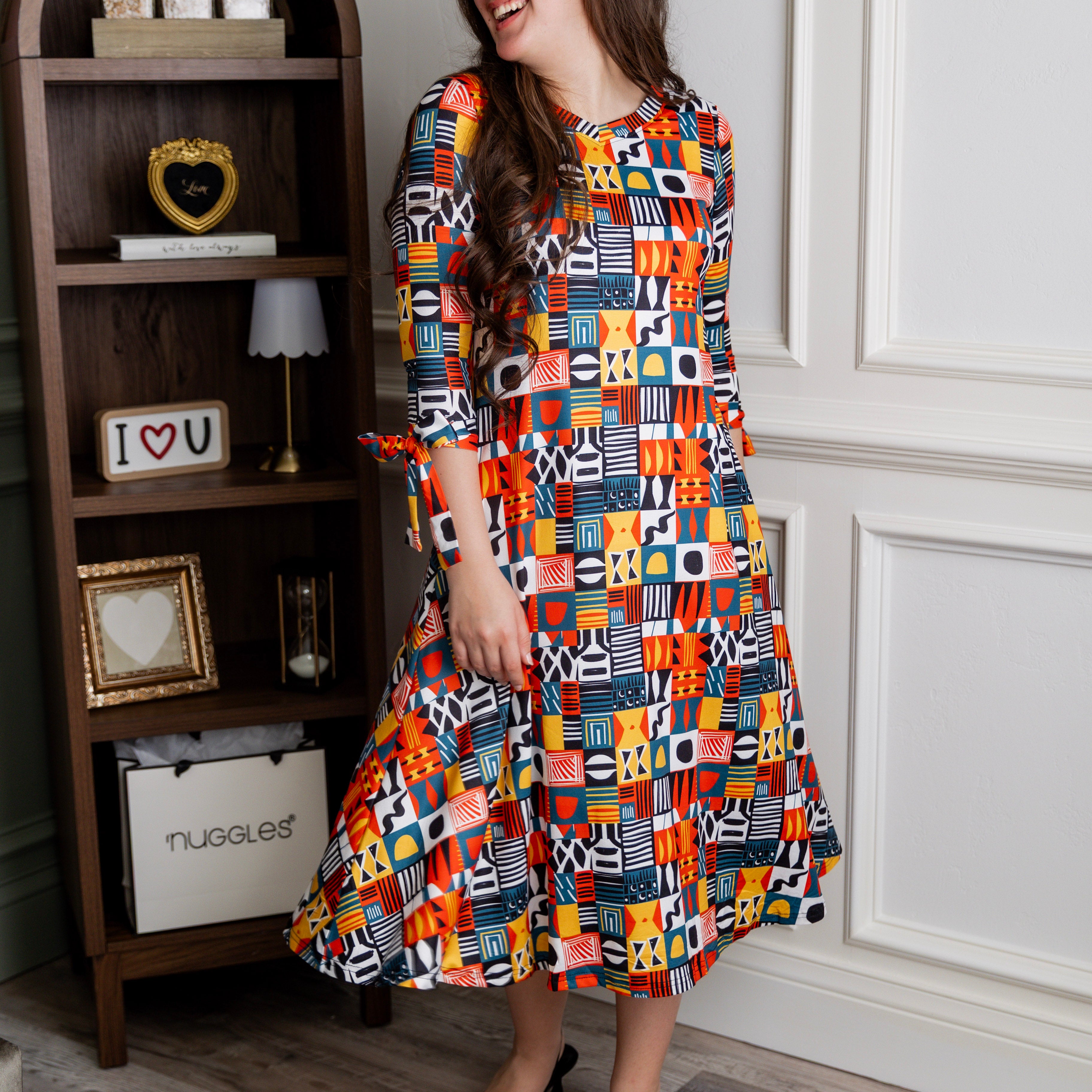 Model wearing Nuggles® Hazel Dress in Playful Patchwork print with bow-tie sleeves