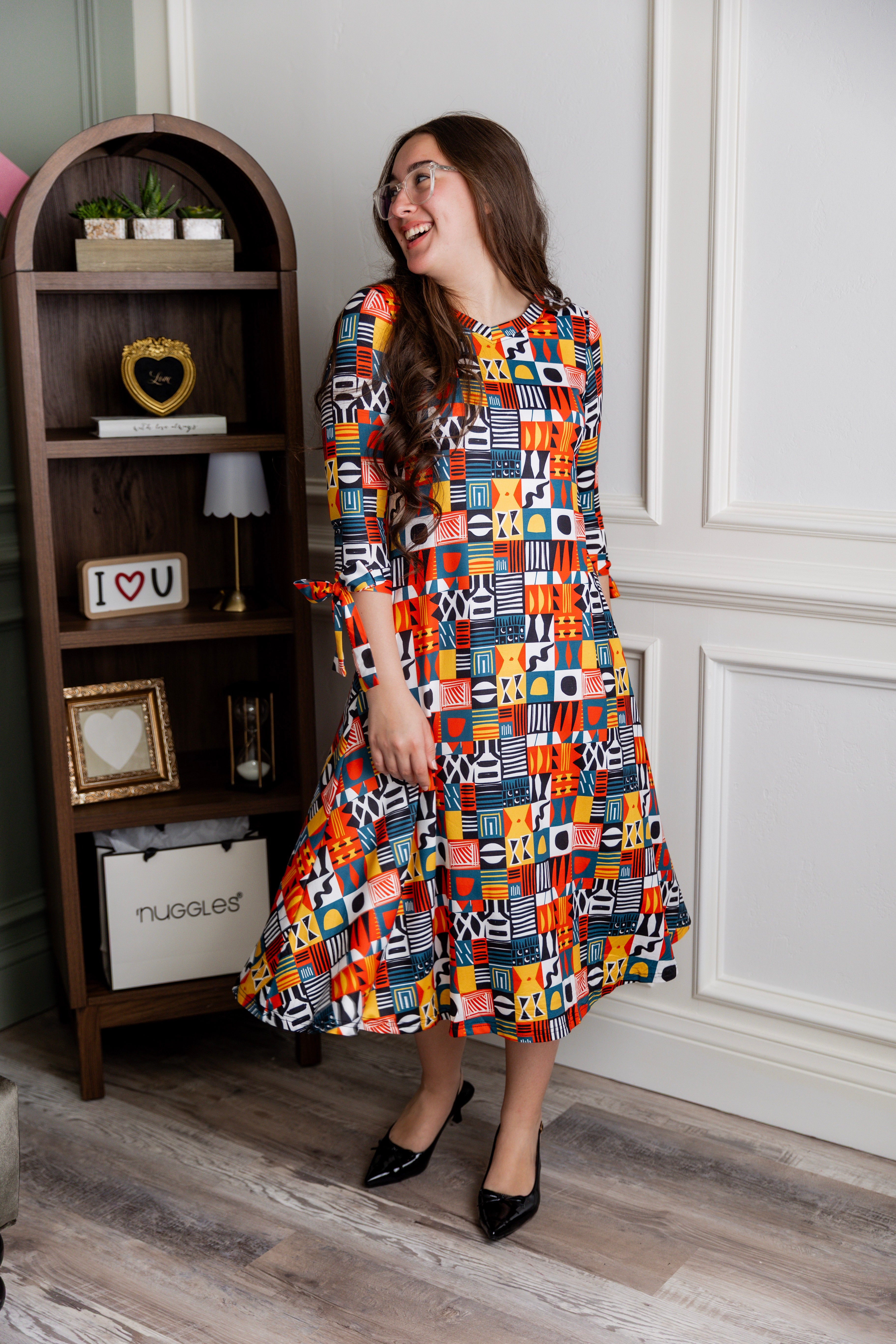 Model wearing Nuggles® Hazel Dress in Playful Patchwork print with bow-tie sleeves