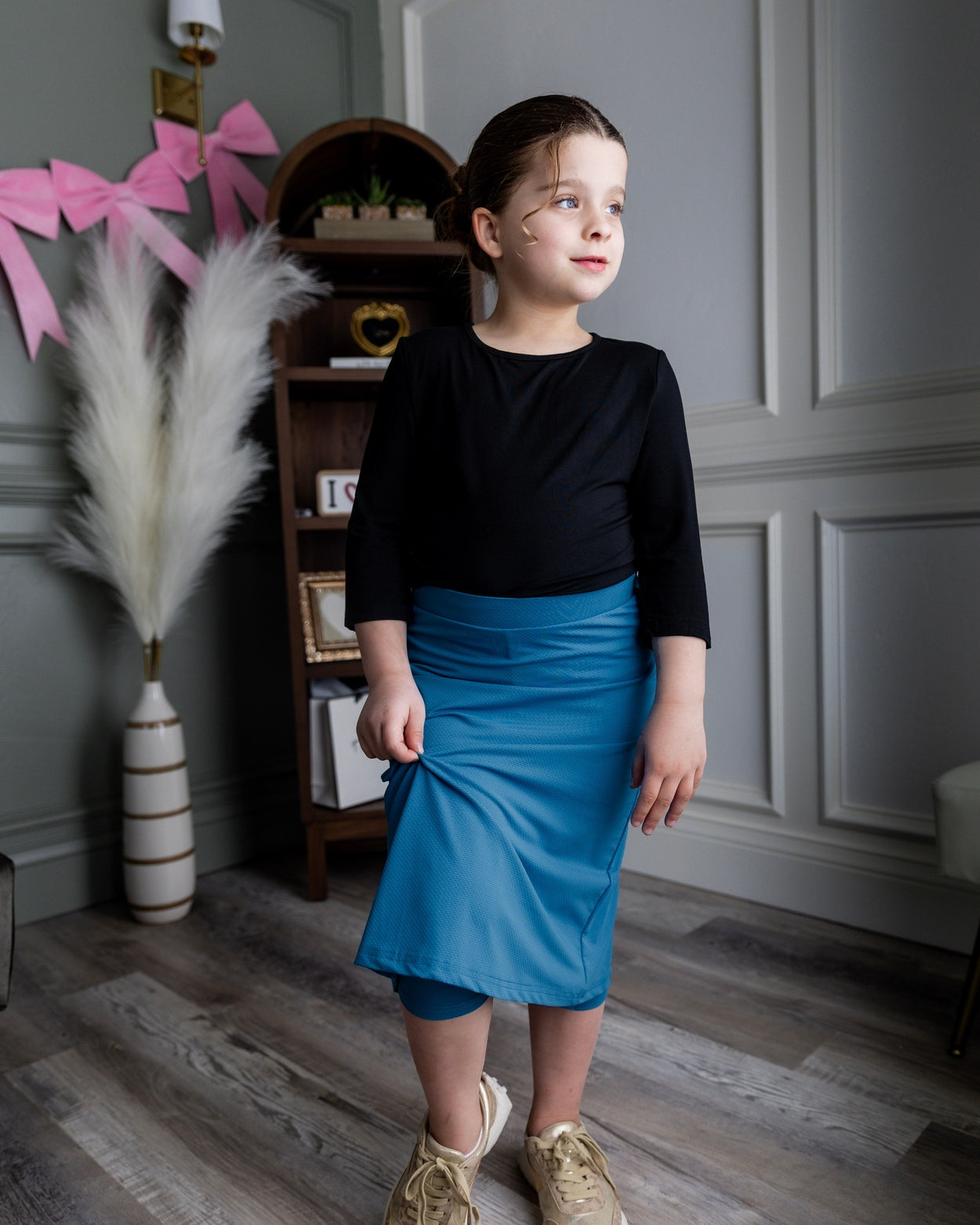 Model wearing Nuggles® Girls' All-Sport Skirt in Turquoise