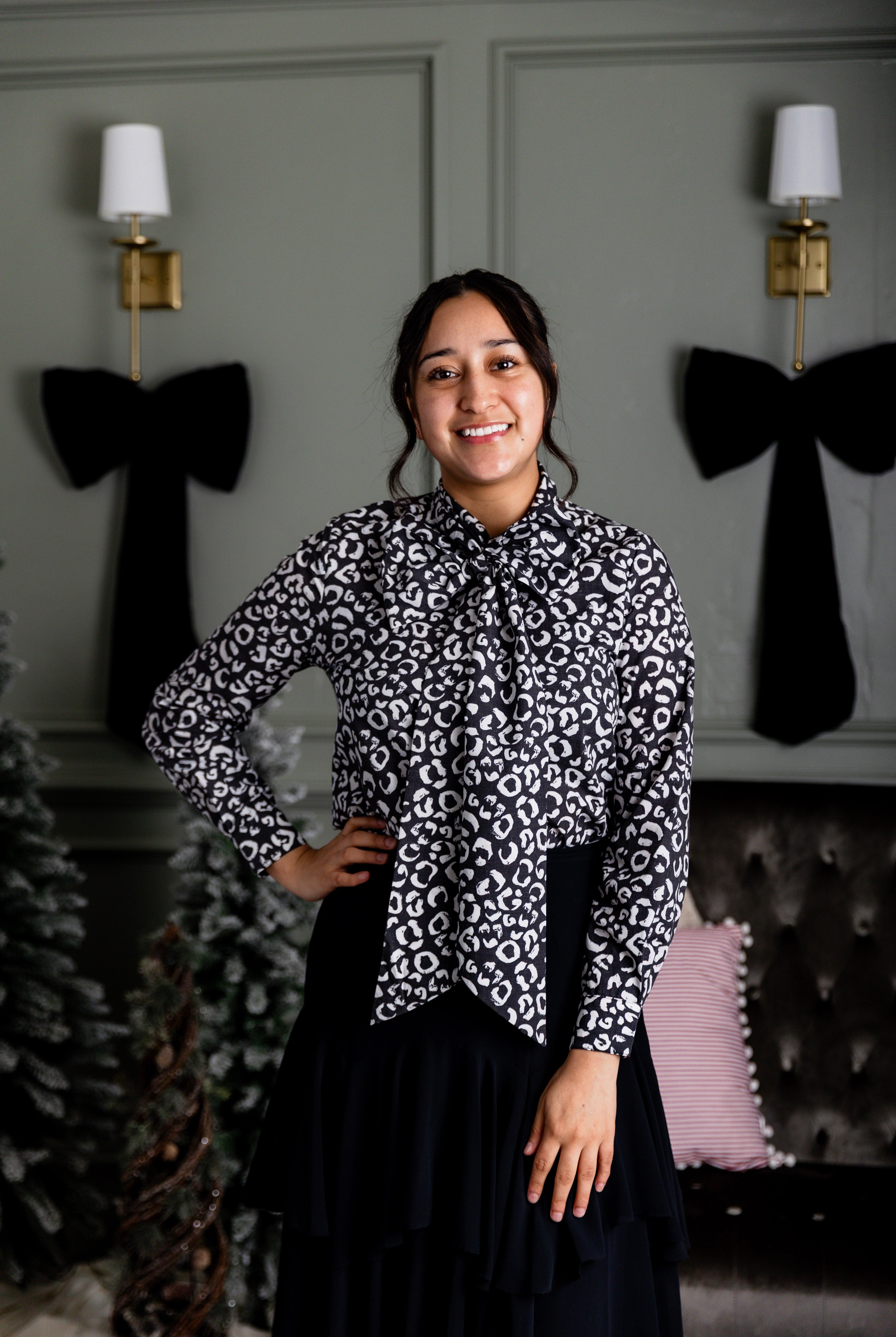 Model wearing Nuggles® Felicity top with large bow tie neckline, modest women's blouse.