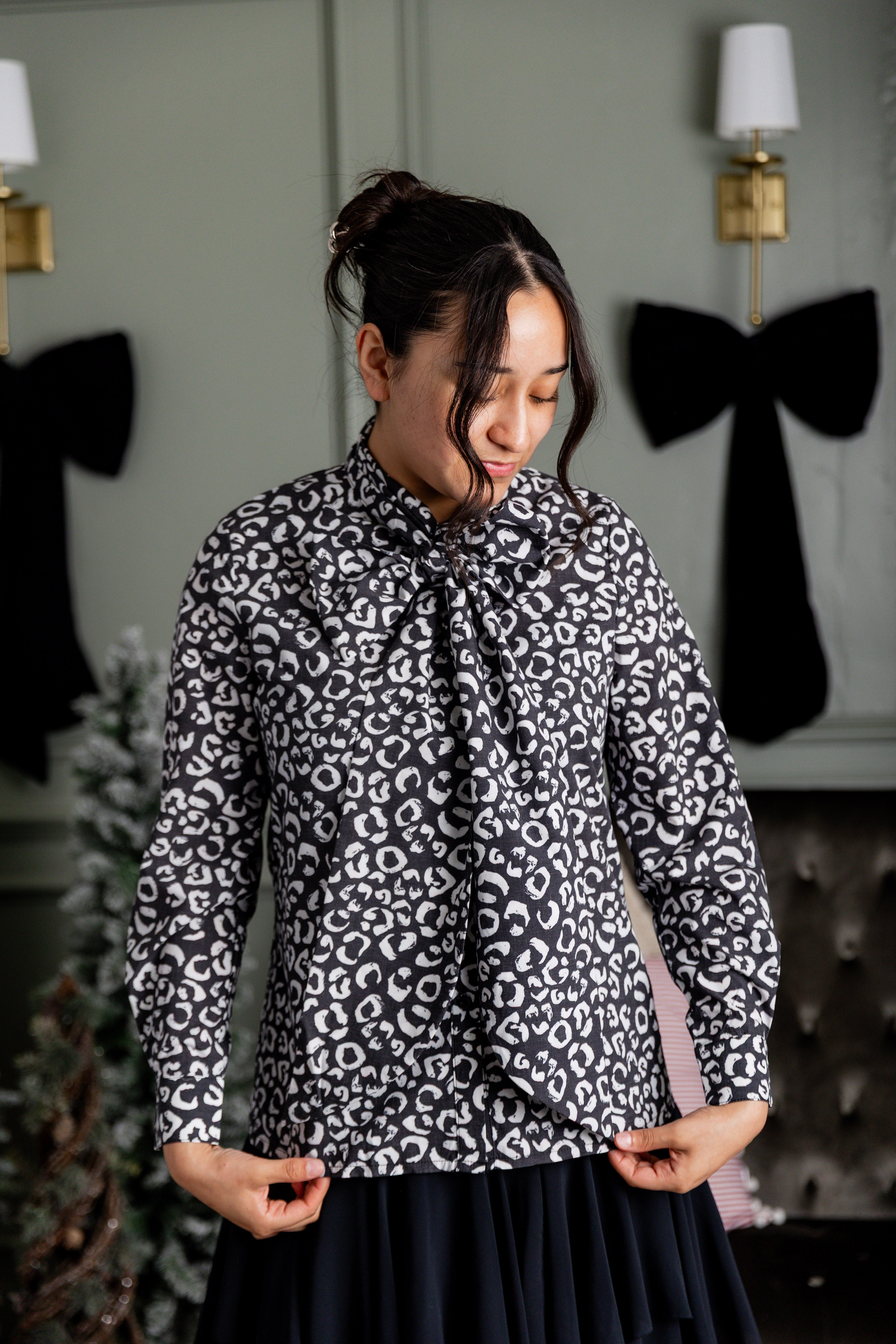 Model wearing Nuggles® Felicity top with large bow tie neckline, modest women's blouse.