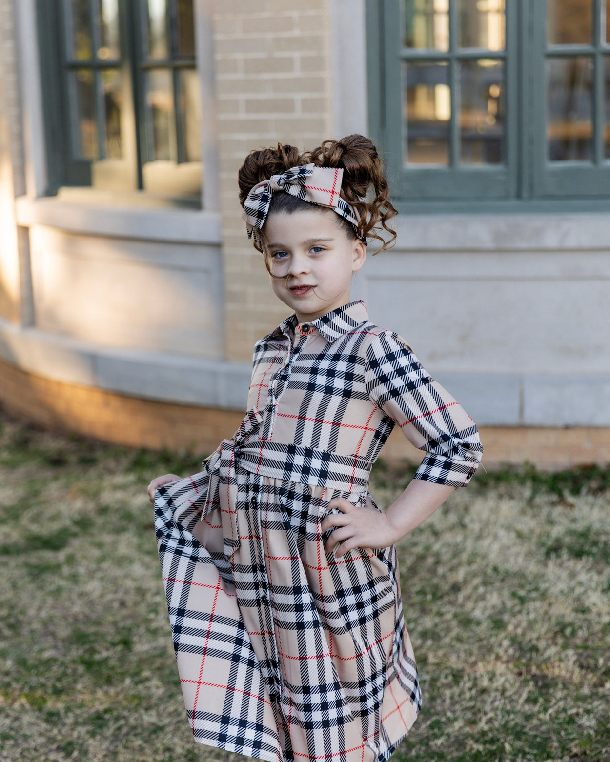 Model wearing the Nuggles® Girls' Rachel Dress in Sand Plaid