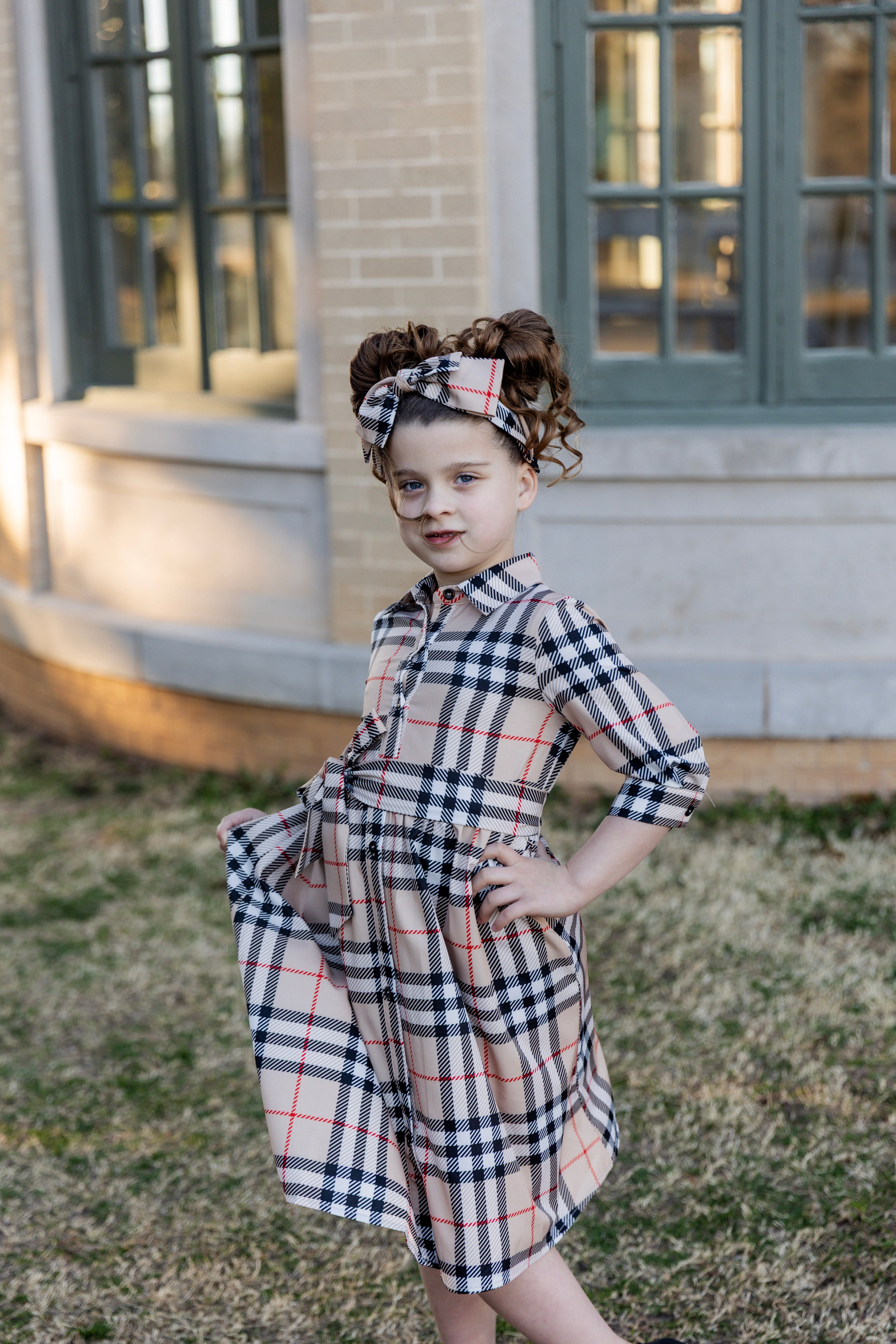 Model wearing the Nuggles® Girls' Rachel Dress in Sand Plaid