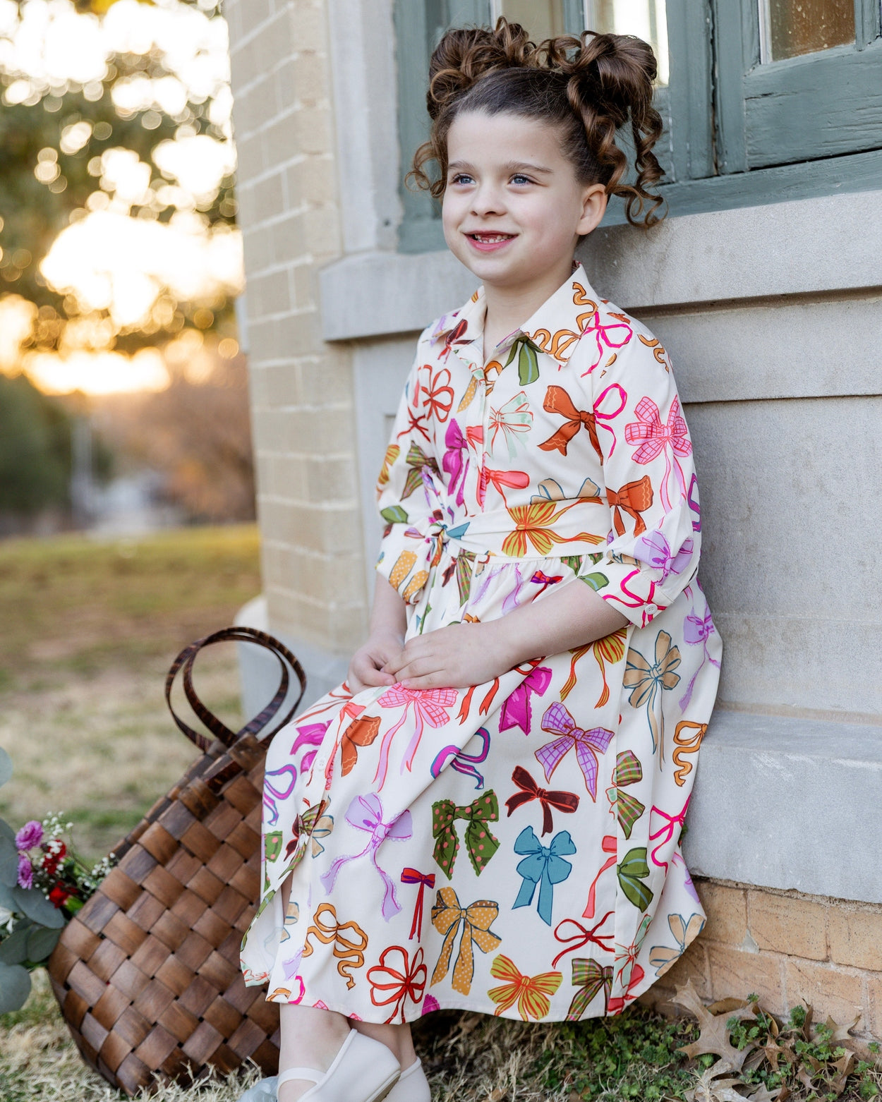 Model wearing the Nuggles® Girls' Rachel Dress in Bow Garden