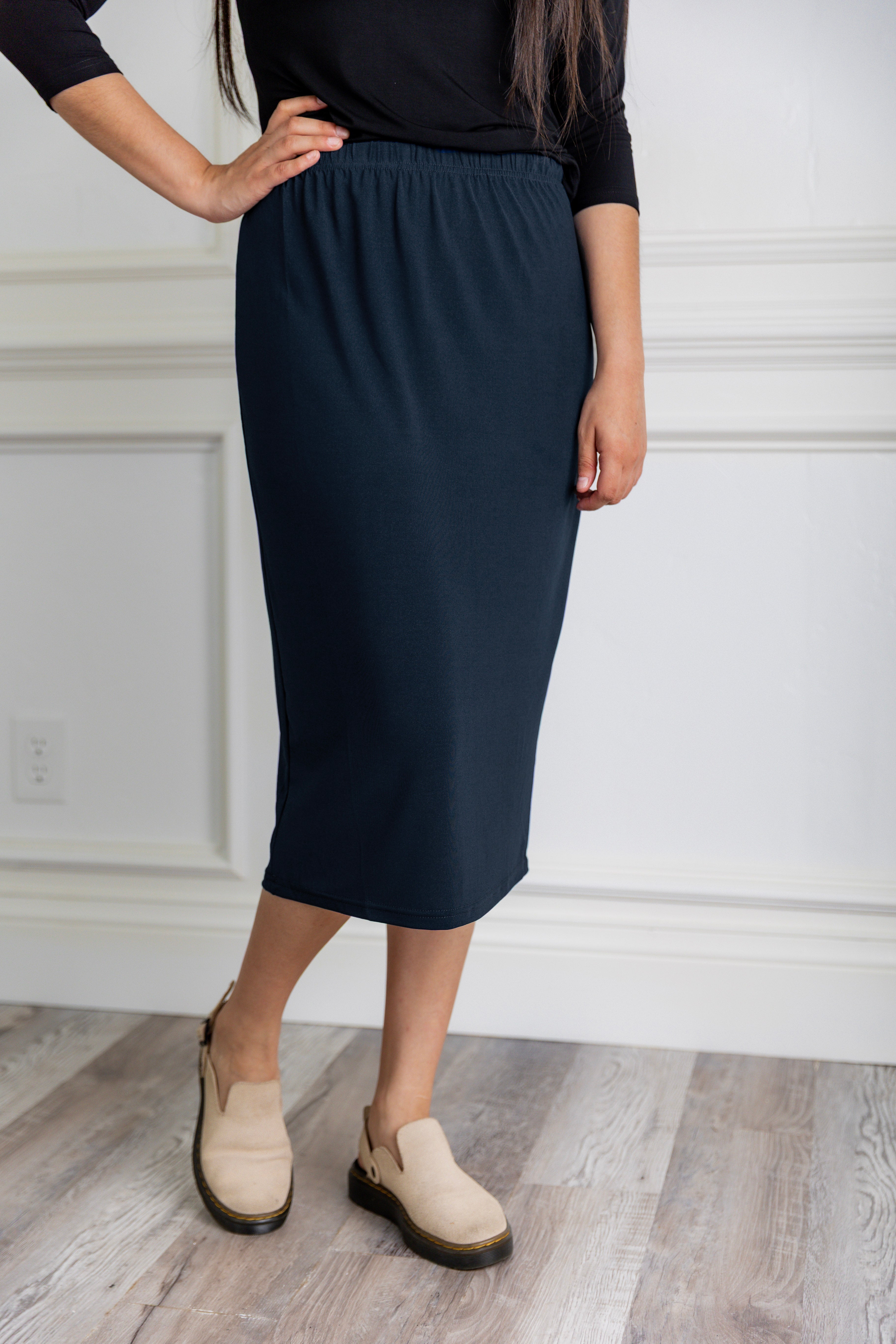 Model wearing a 27-inch classic lightweight midi skirt with an elastic waistband, styled modestly for everyday or church wear.