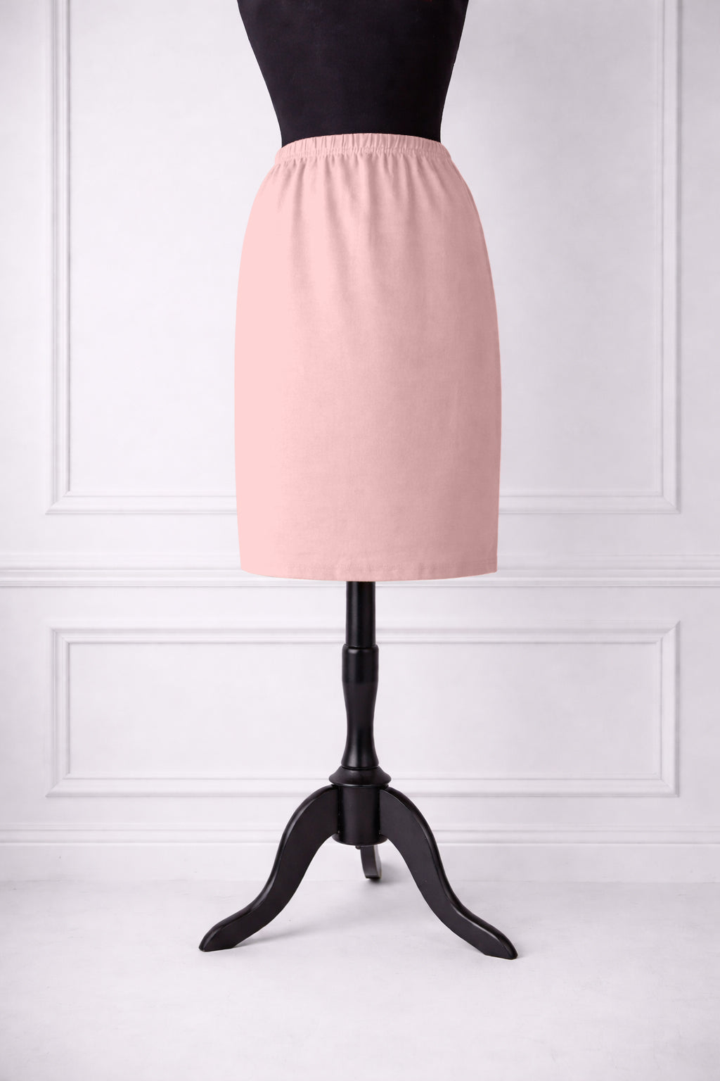 rose skirt on a mannequin against a white paneled wall.