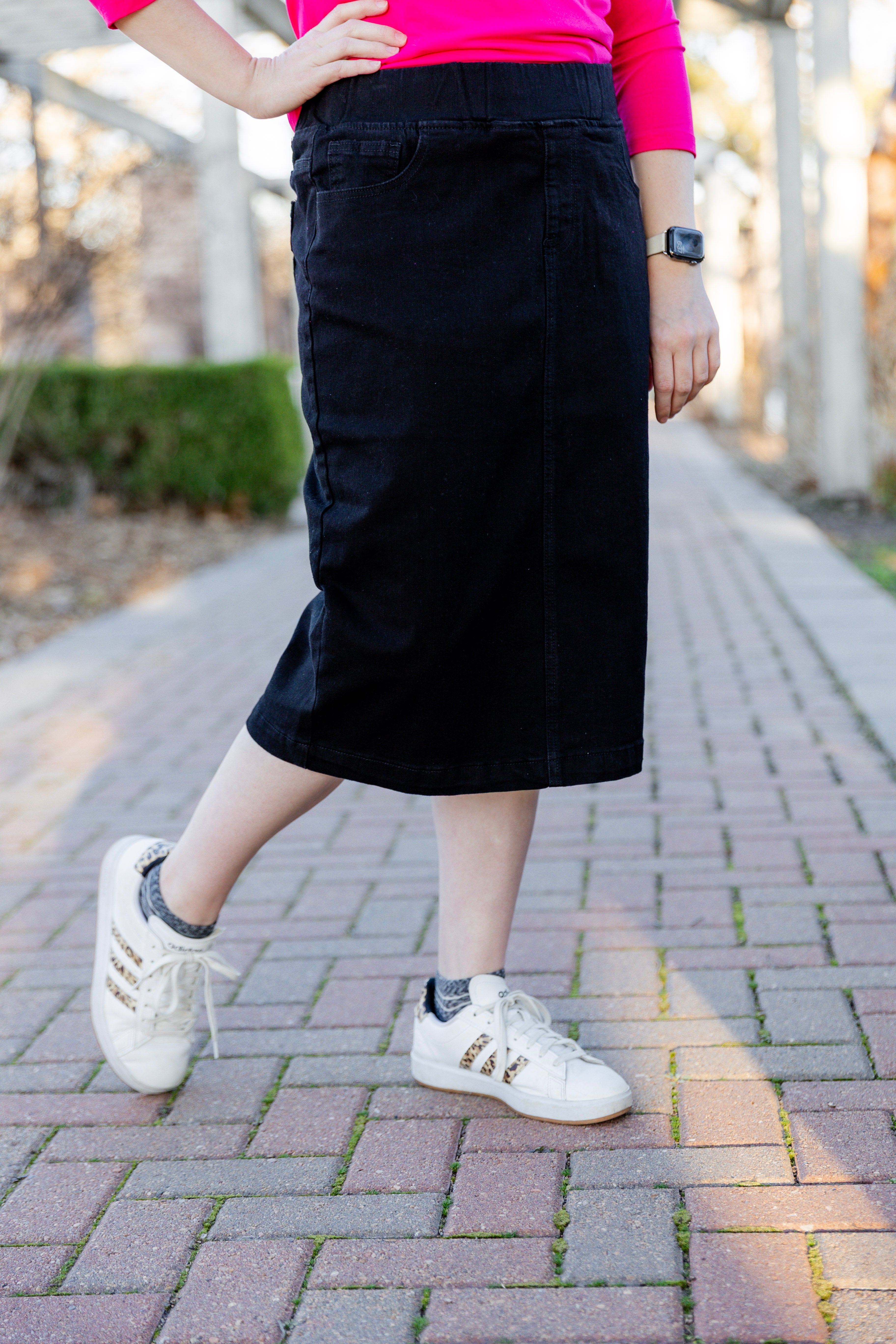 Nuggles® denim midi skirt with soft stretch fabric, wide elastic waistband, modest length, and functional pockets. Available in 27", 31", and 34" lengths.