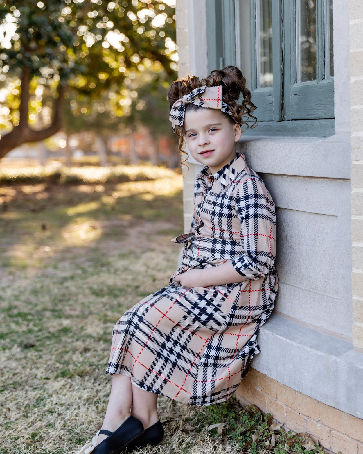 Model wearing the Nuggles® Girls' Rachel Dress in Sand Plaid