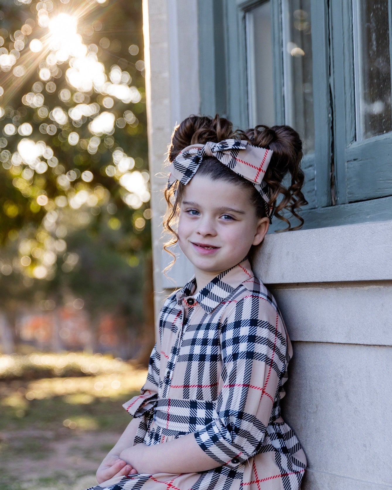 Model wearing the Nuggles® Girls' Rachel Dress in Sand Plaid