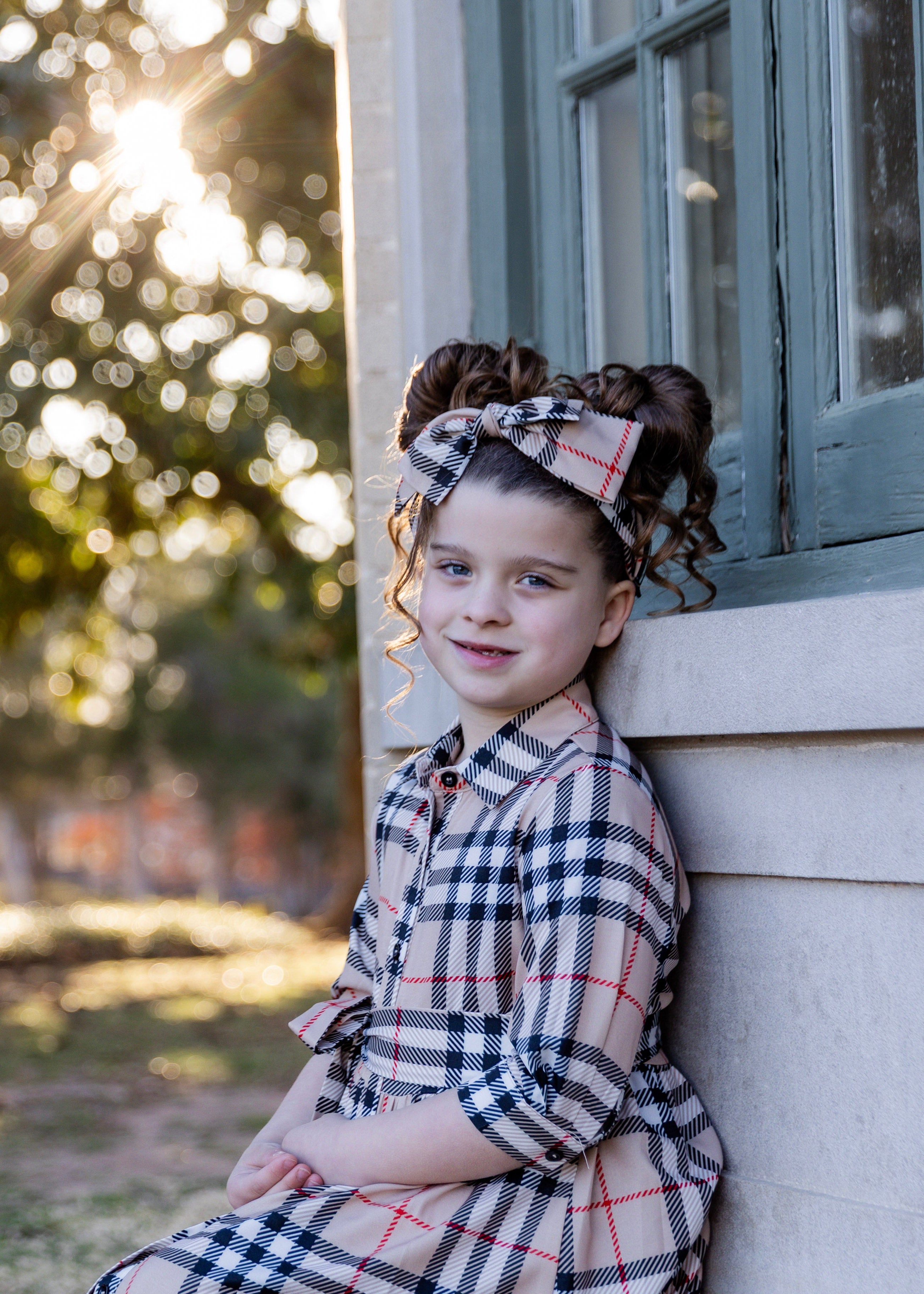 Model wearing the Nuggles® Girls' Rachel Dress in Sand Plaid