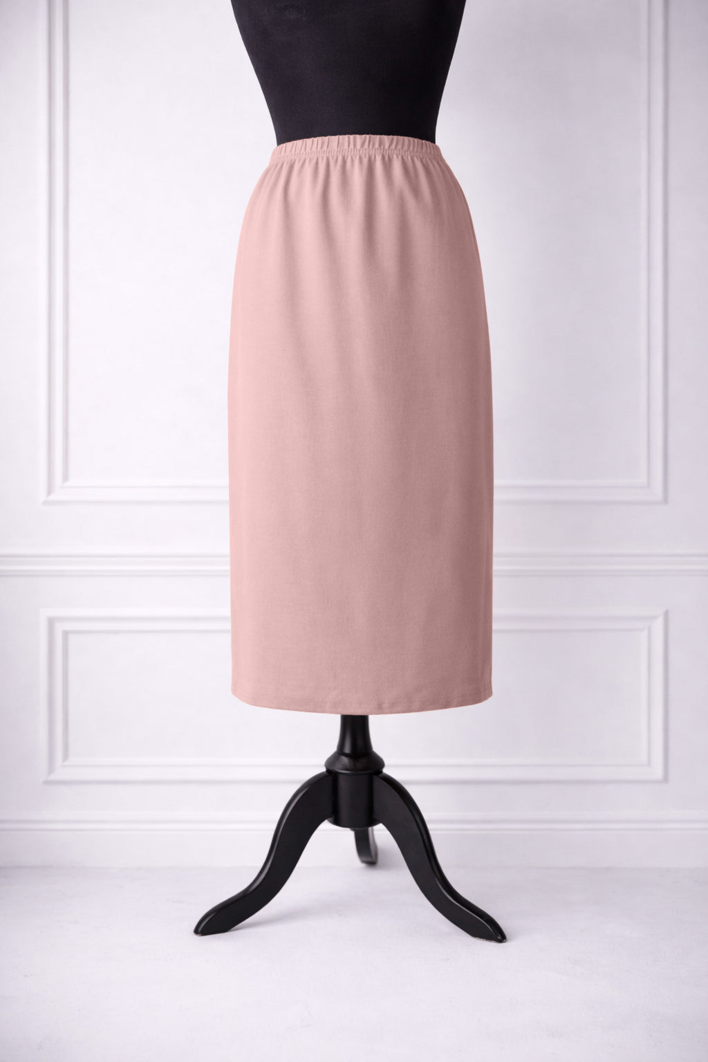 rose skirt on a mannequin against a white paneled wall.