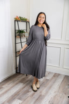 Modest Willow Solid Colors Dress by Nuggles® featuring a gathered waist, balloon sleeves, and side pockets; shown in various solid colors and angles for a stylish, comfortable everyday look.