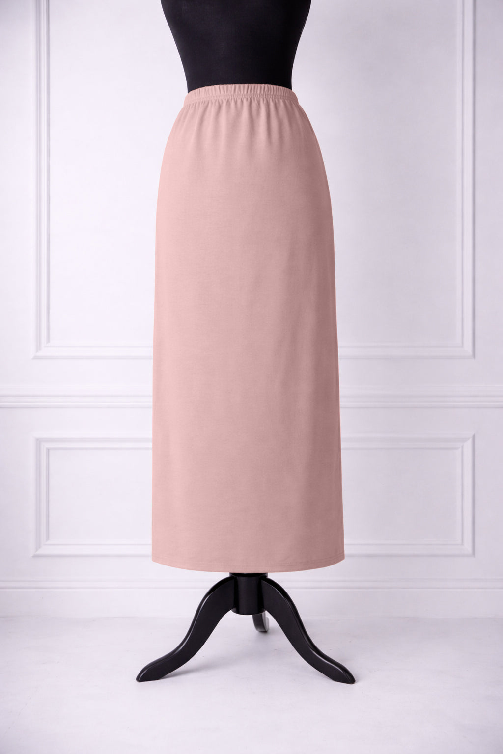 rose skirt on a mannequin against a white paneled wall.