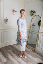 Modest light blue floral print tunic for women – Nuggles® Rose Top with high-low ruffle hem and 3/4 sleeves.