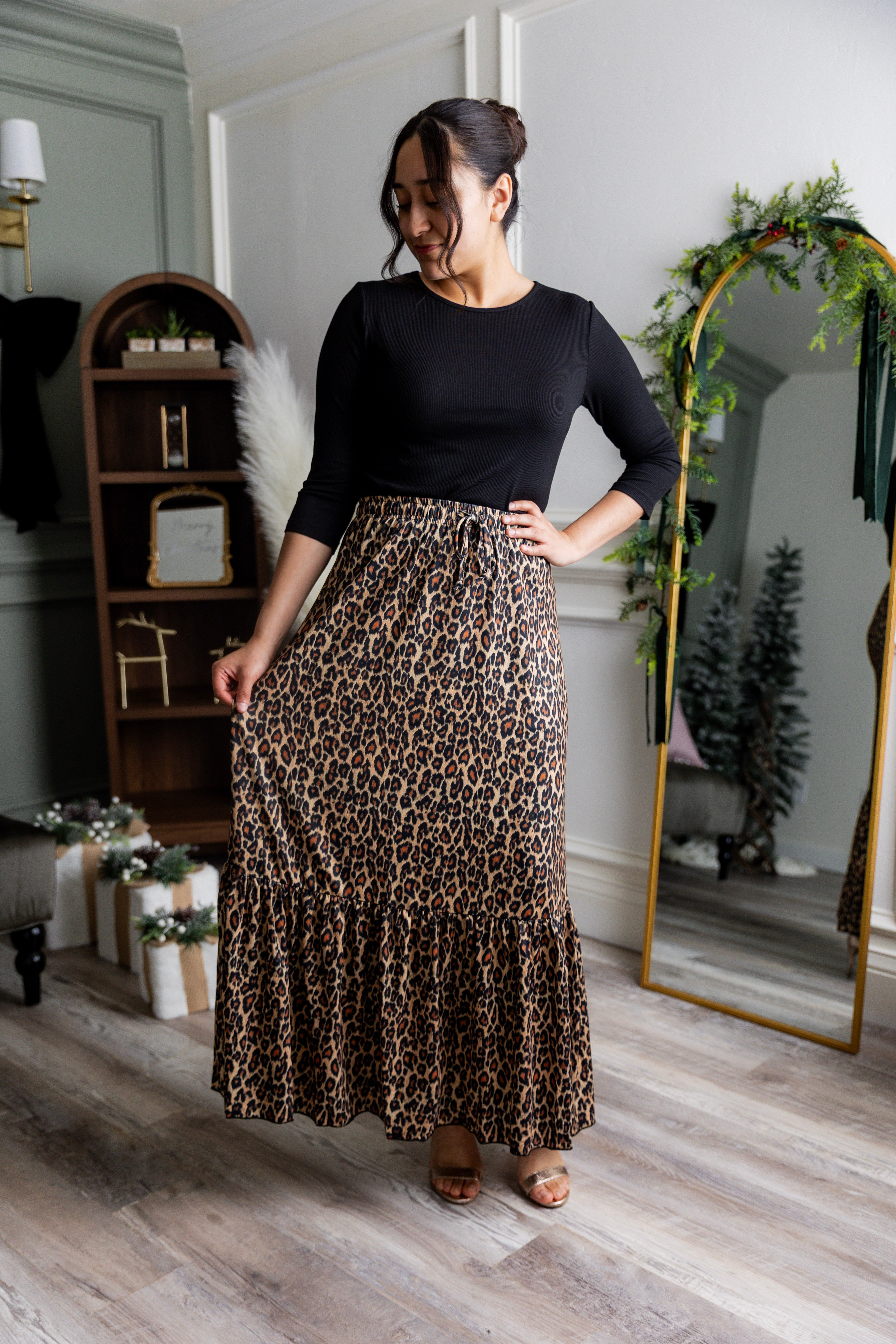 Model wearing the Nuggles® Sage Skirt in leopard print, designed with a flowy tiered hem and comfortable elastic waistband.