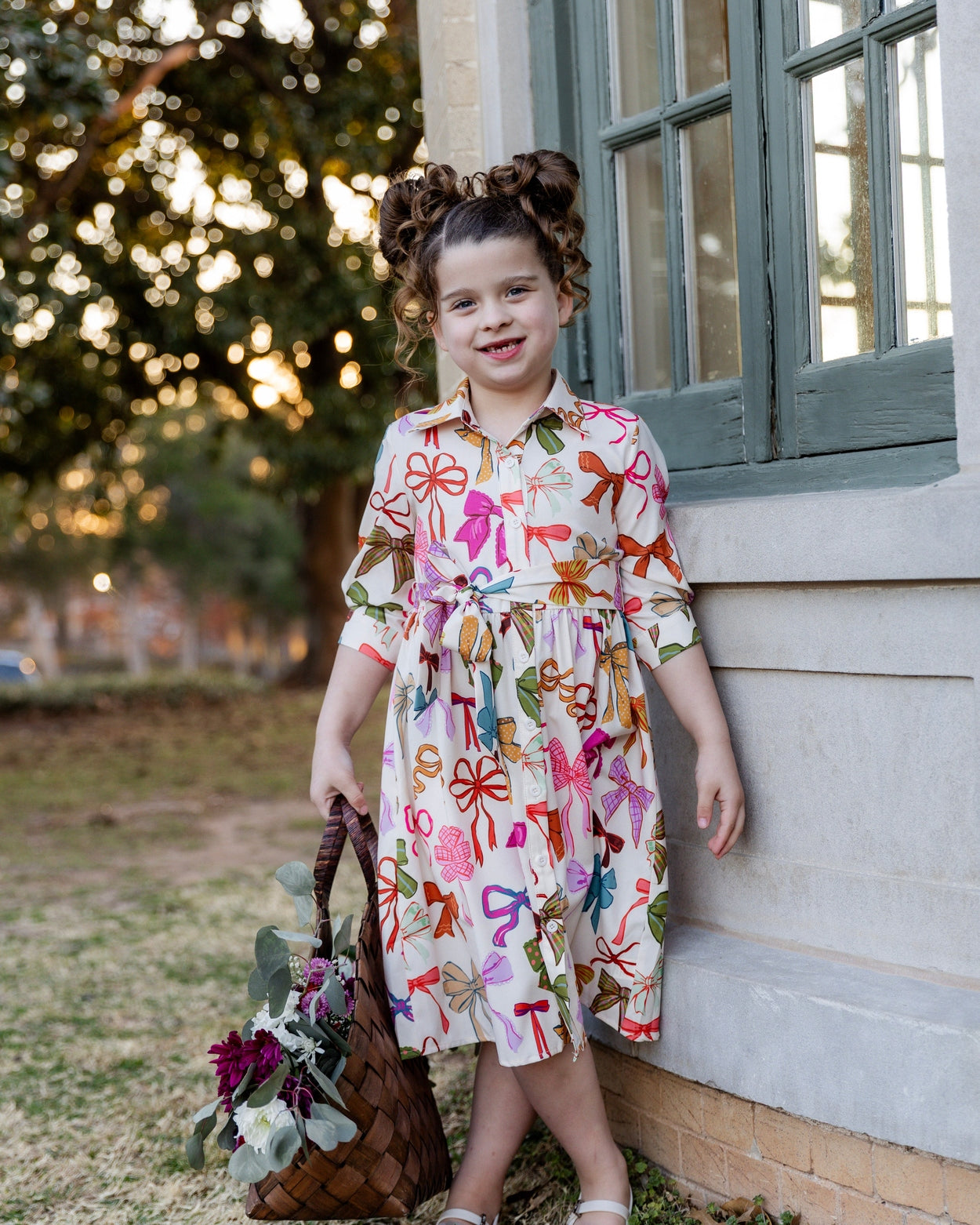 Model wearing the Nuggles® Girls' Rachel Dress in Bow Garden