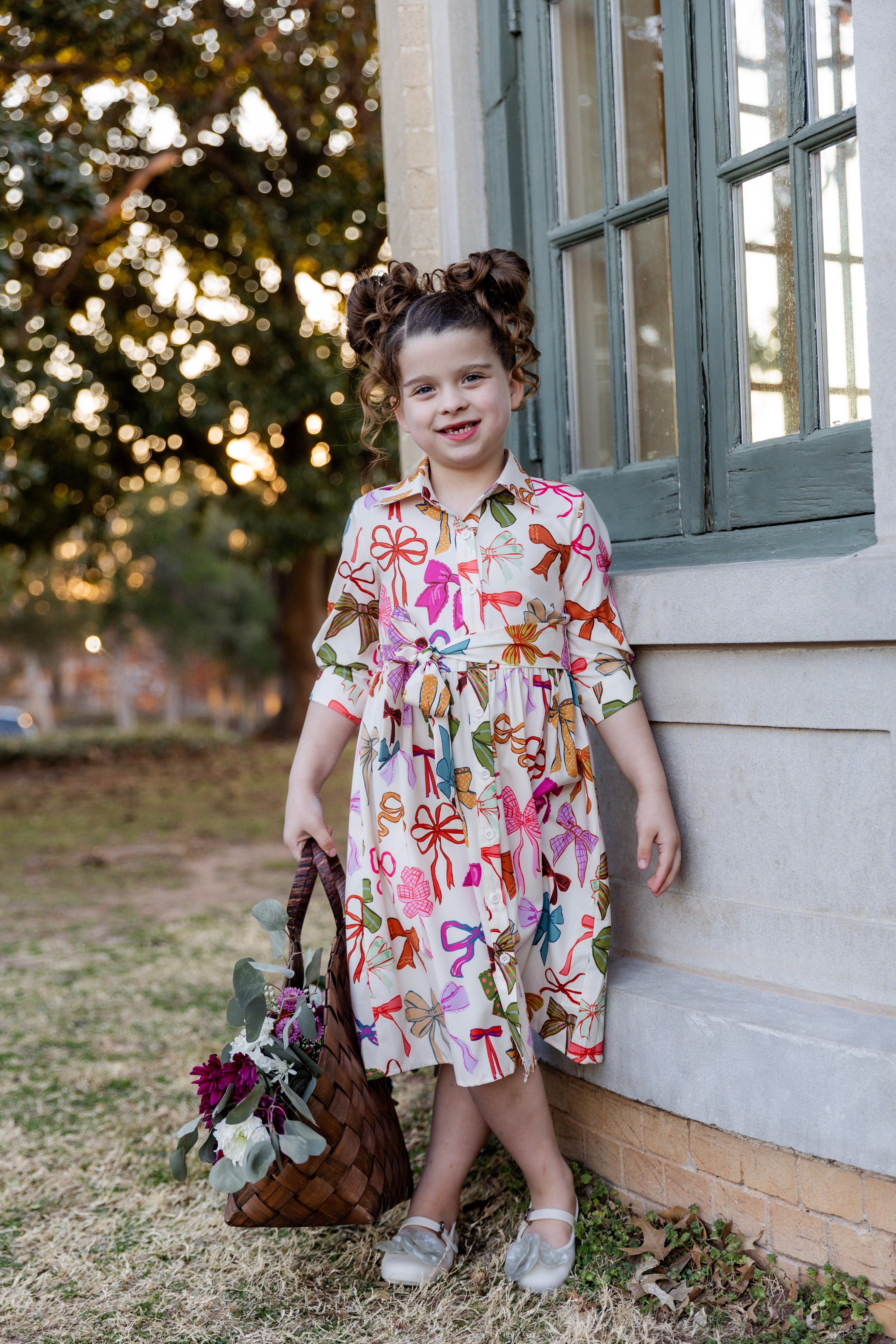 Model wearing the Nuggles® Girls' Rachel Dress in Bow Garden