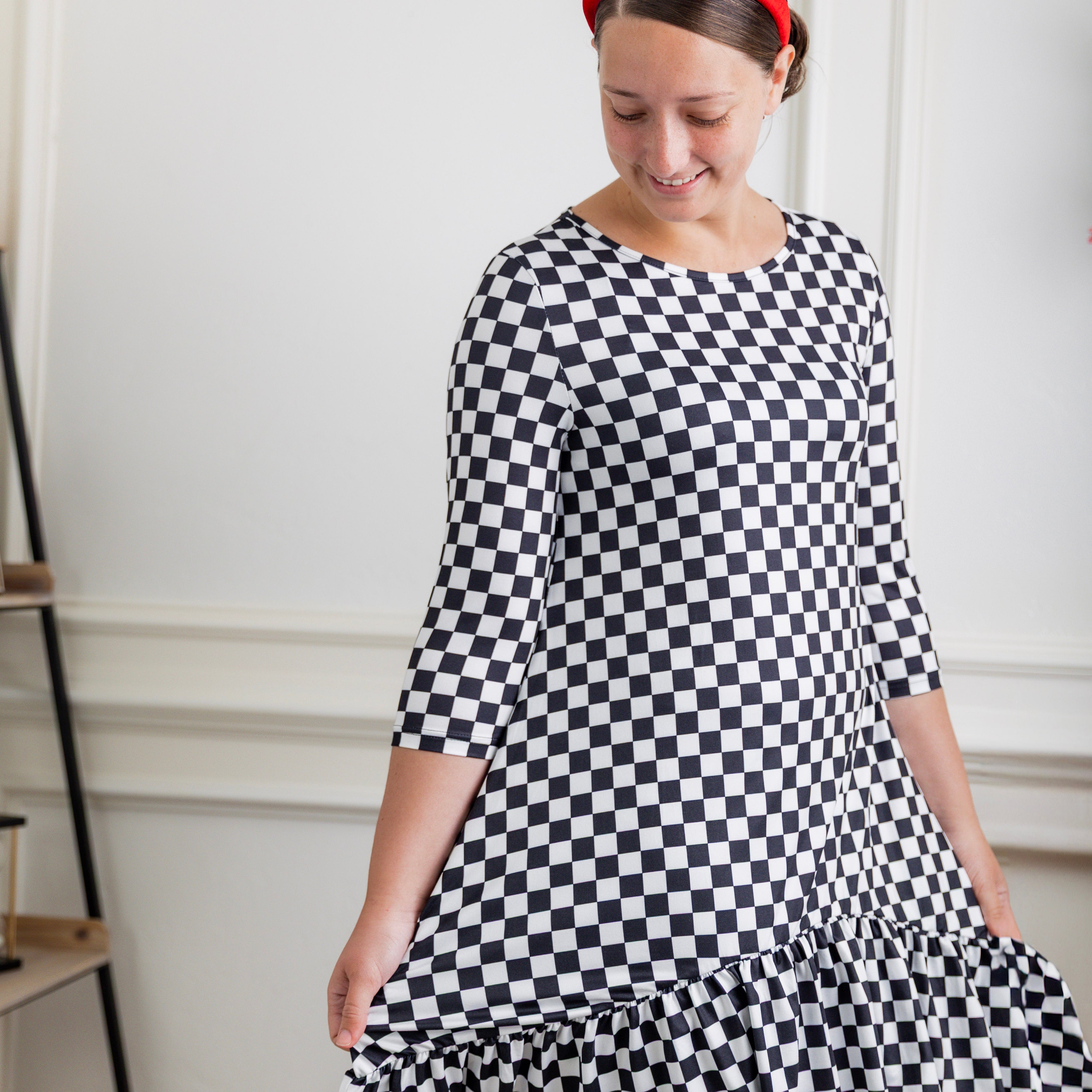 Modest women's black and white checkerboard ruffle tunic – Nuggles® Rose Top with 3/4 sleeves and swing hem.