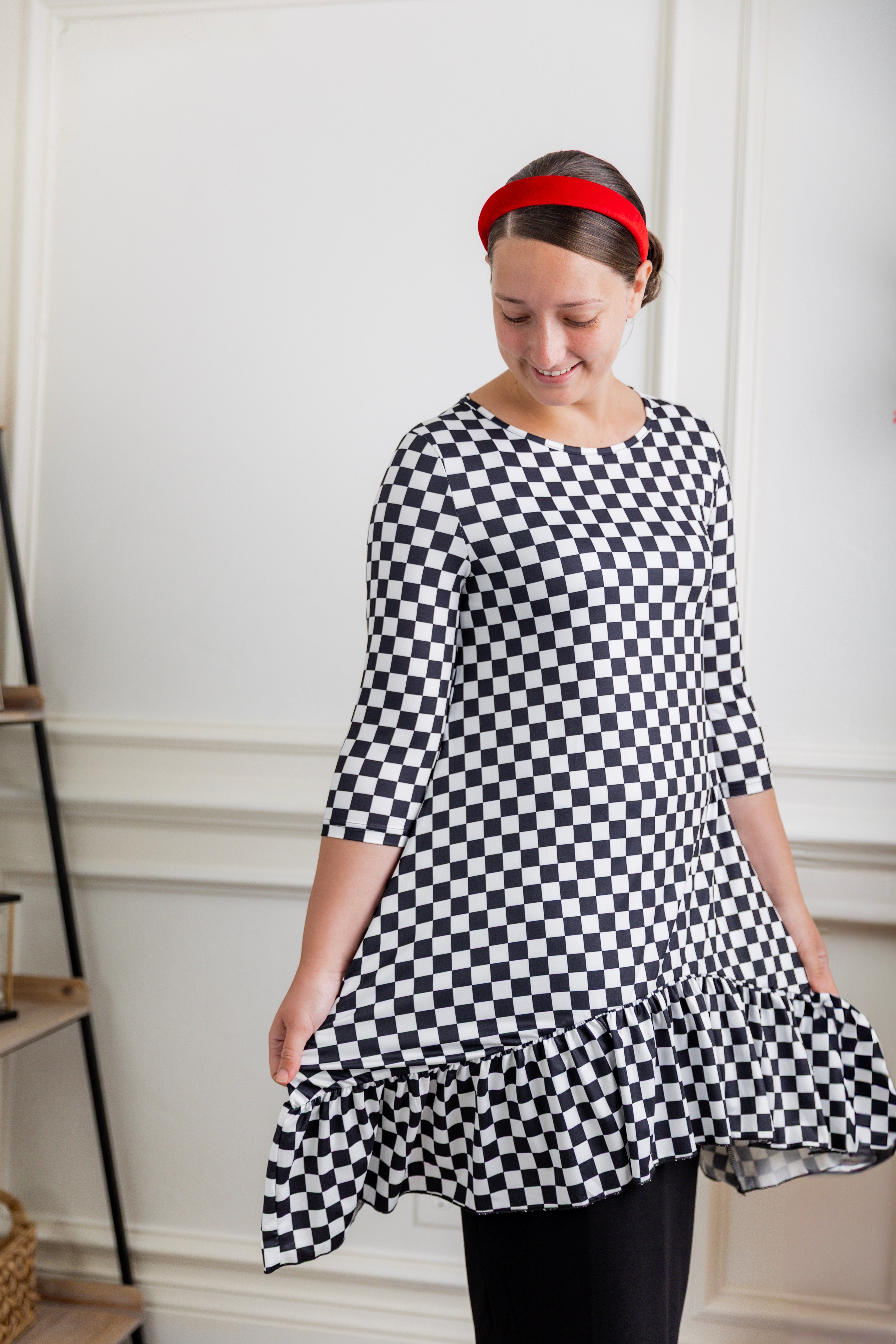 Modest women's black and white checkerboard ruffle tunic – Nuggles® Rose Top with 3/4 sleeves and swing hem.