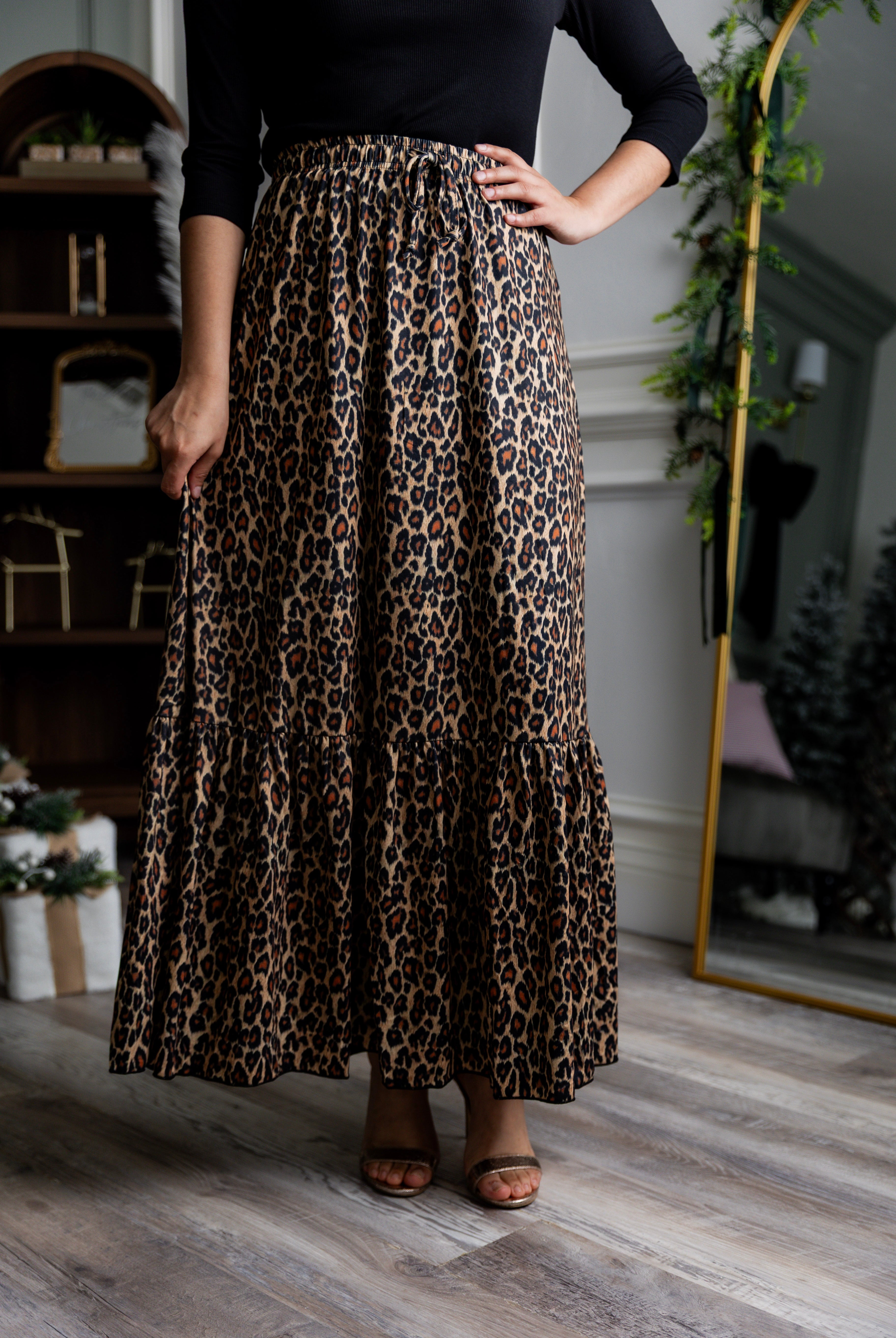Model wearing the Nuggles® Sage Skirt in leopard print, designed with a flowy tiered hem and comfortable elastic waistband.