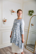Modest light blue floral print tunic for women – Nuggles® Rose Top with high-low ruffle hem and 3/4 sleeves.