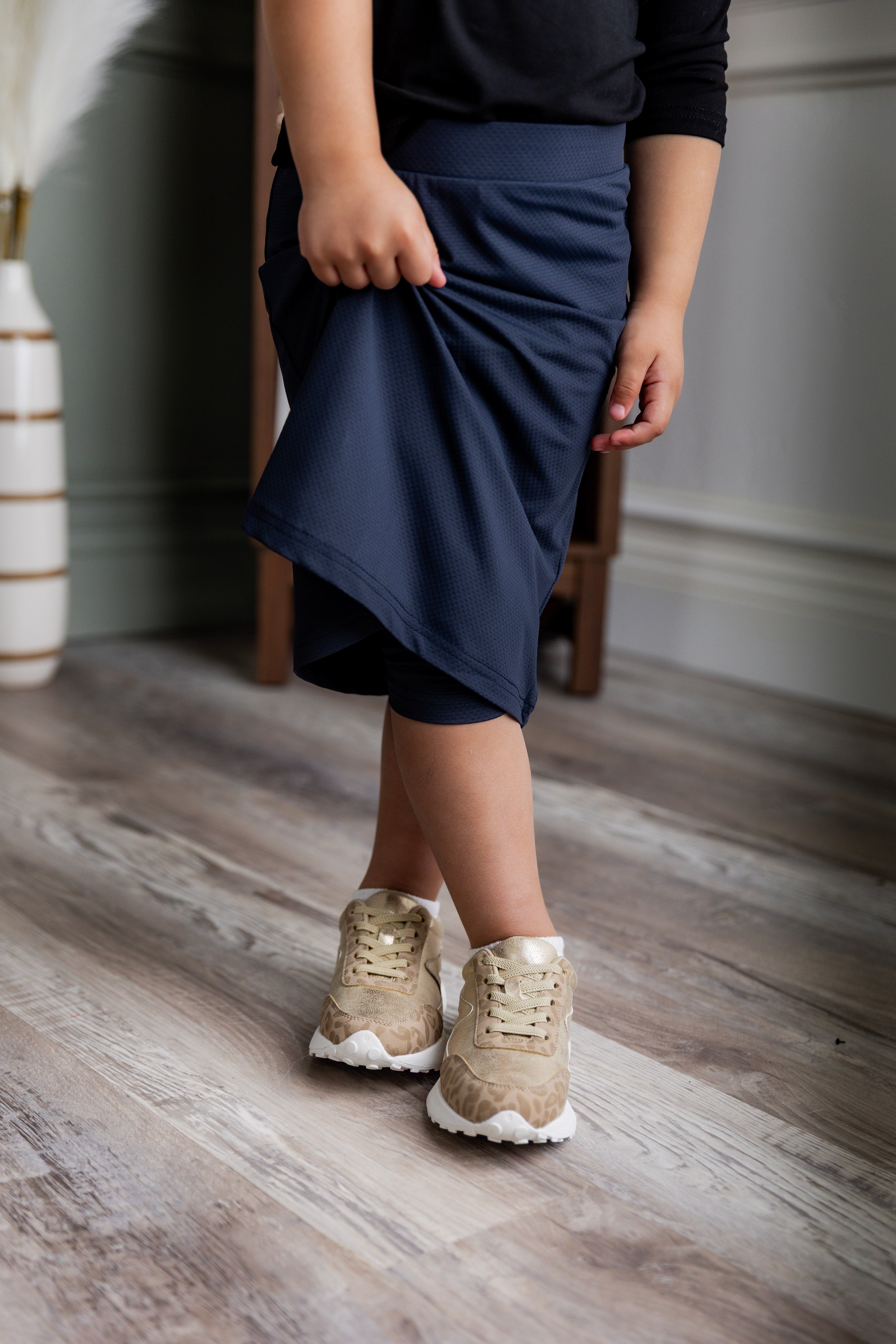 Model wearing Nuggles® Girls' All-Sport Skirt in Navy