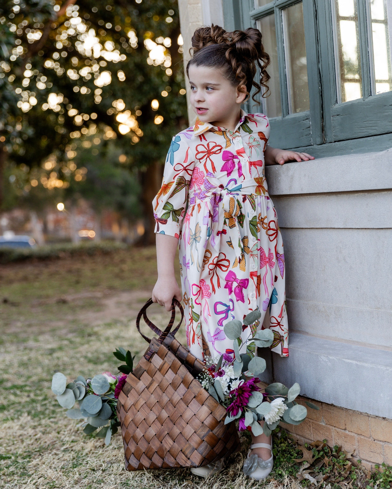 Model wearing the Nuggles® Girls' Rachel Dress in Bow Garden