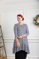 Modest women's black and white checkerboard ruffle tunic – Nuggles® Rose Top with 3/4 sleeves and swing hem.