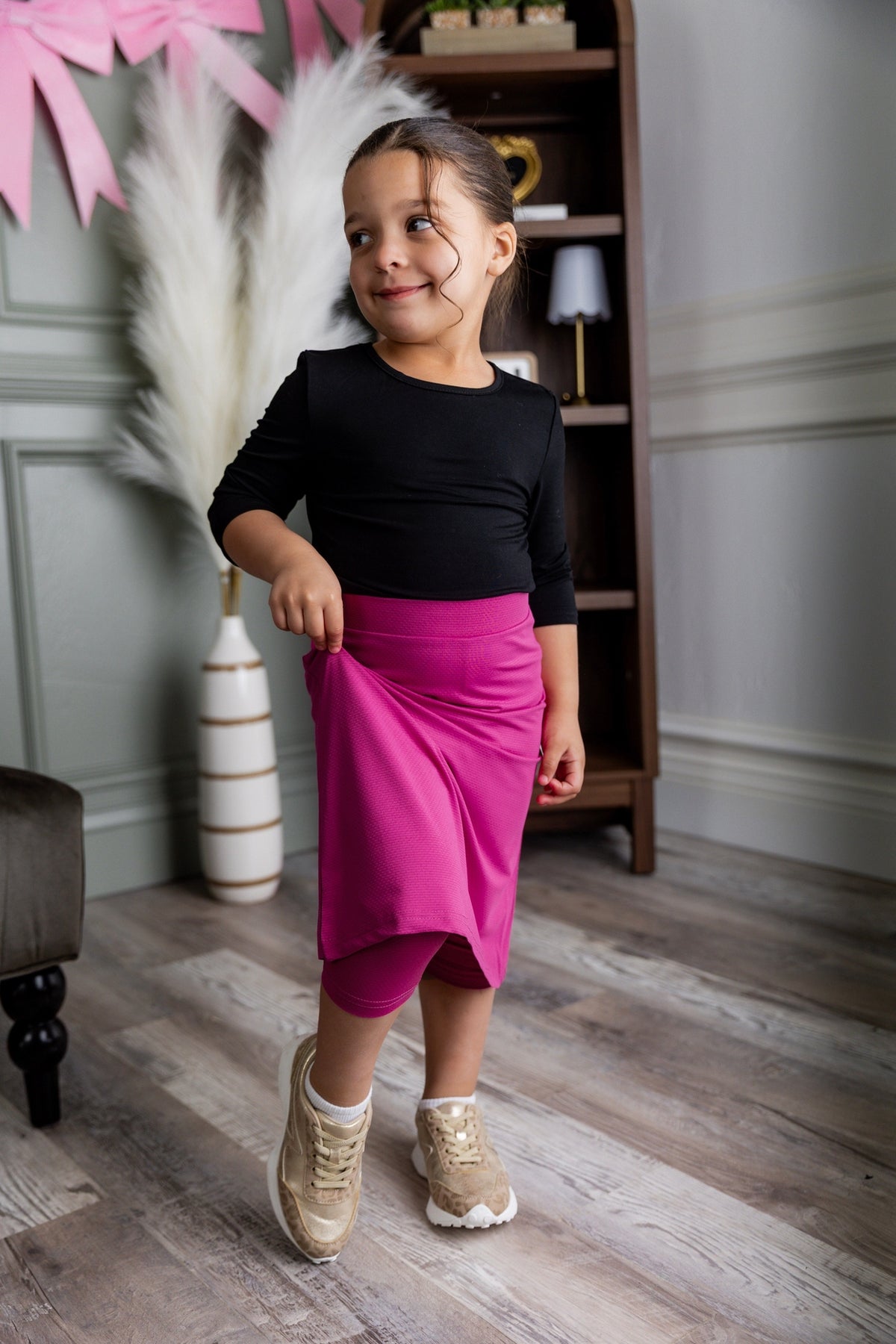 Model wearing Nuggles® Girls' All-Sport Skirt in Hot Pink