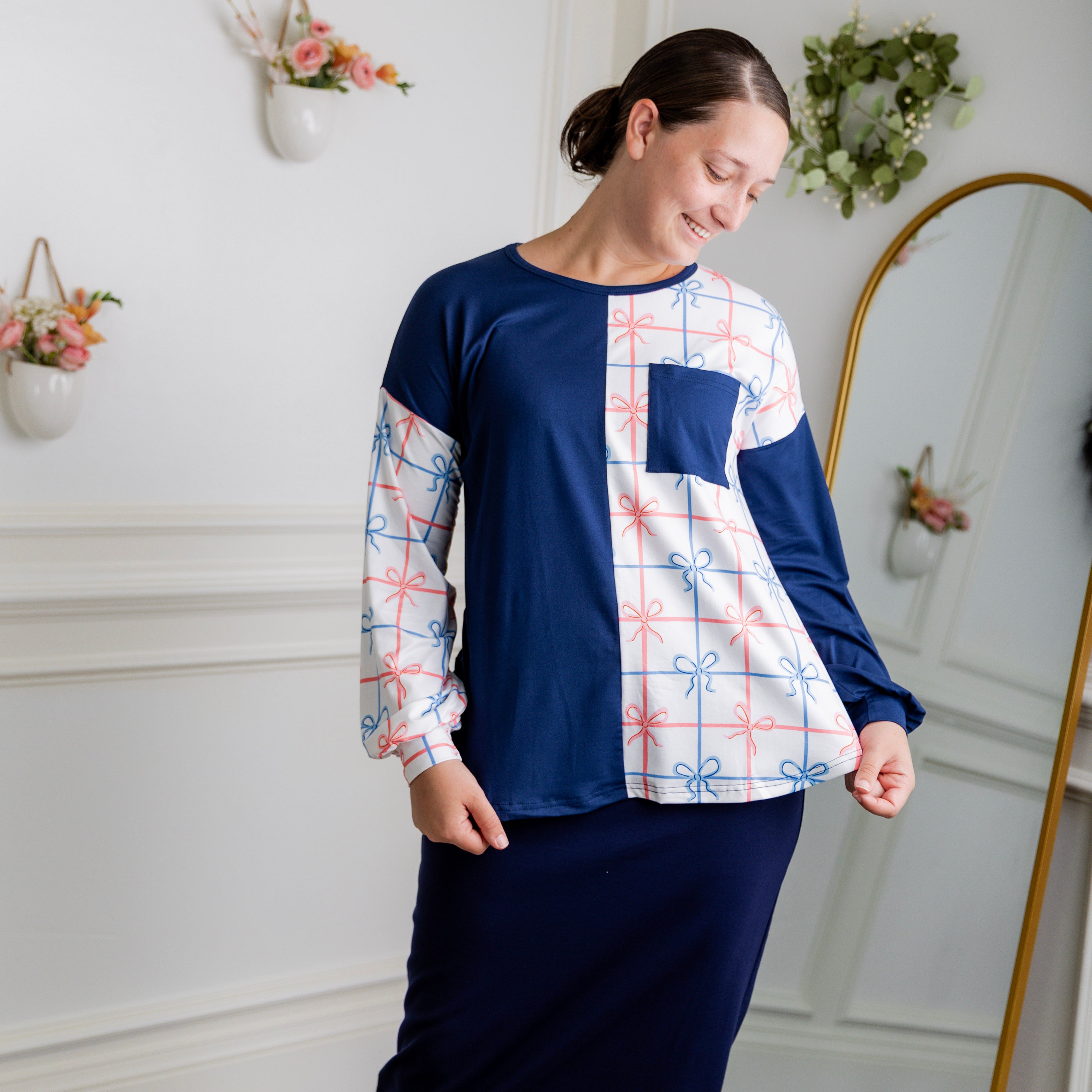Model wearing the Nuggles® Harlow Top with red and navy color block design.