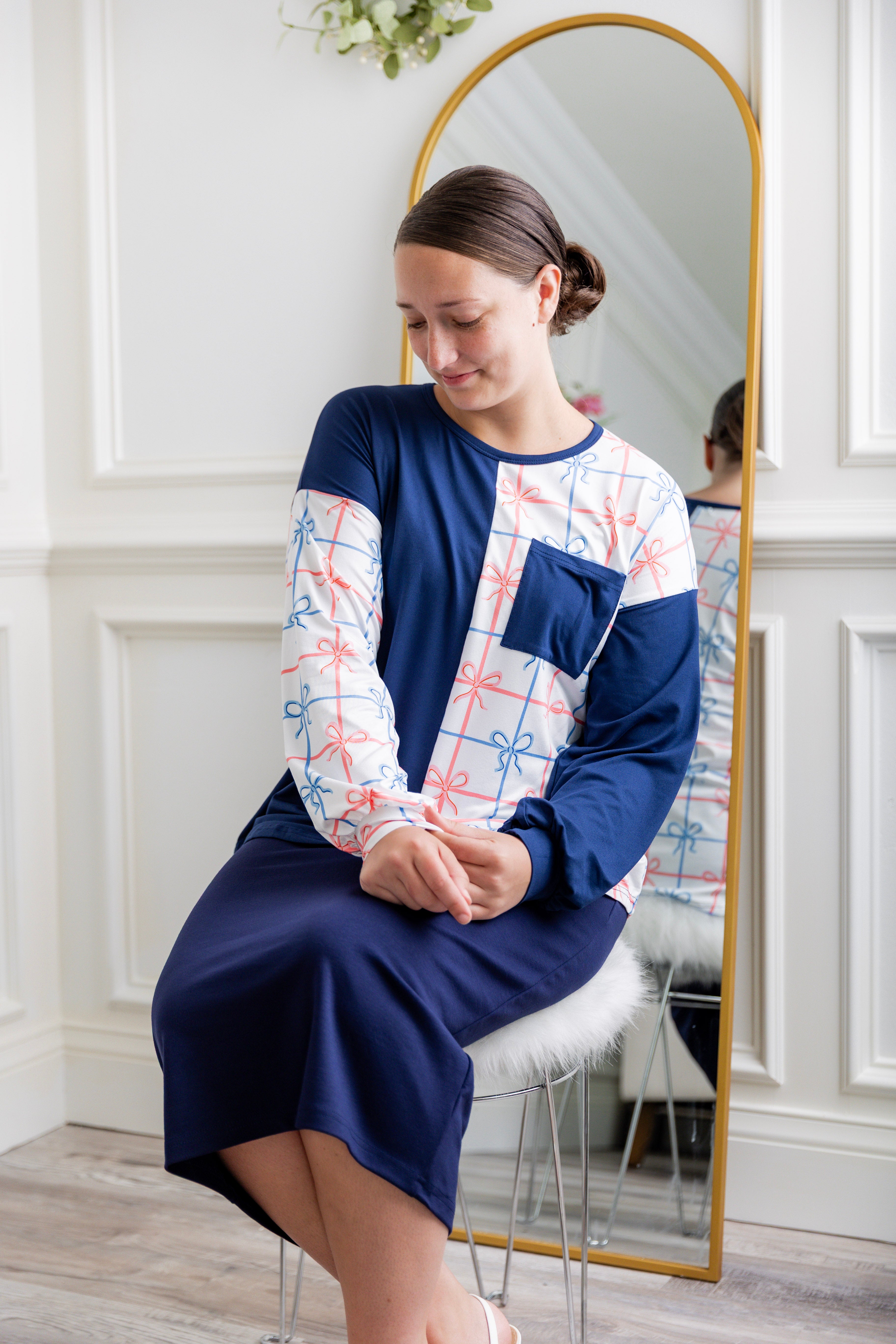 Model wearing the Nuggles® Harlow Top with red and navy color block design.