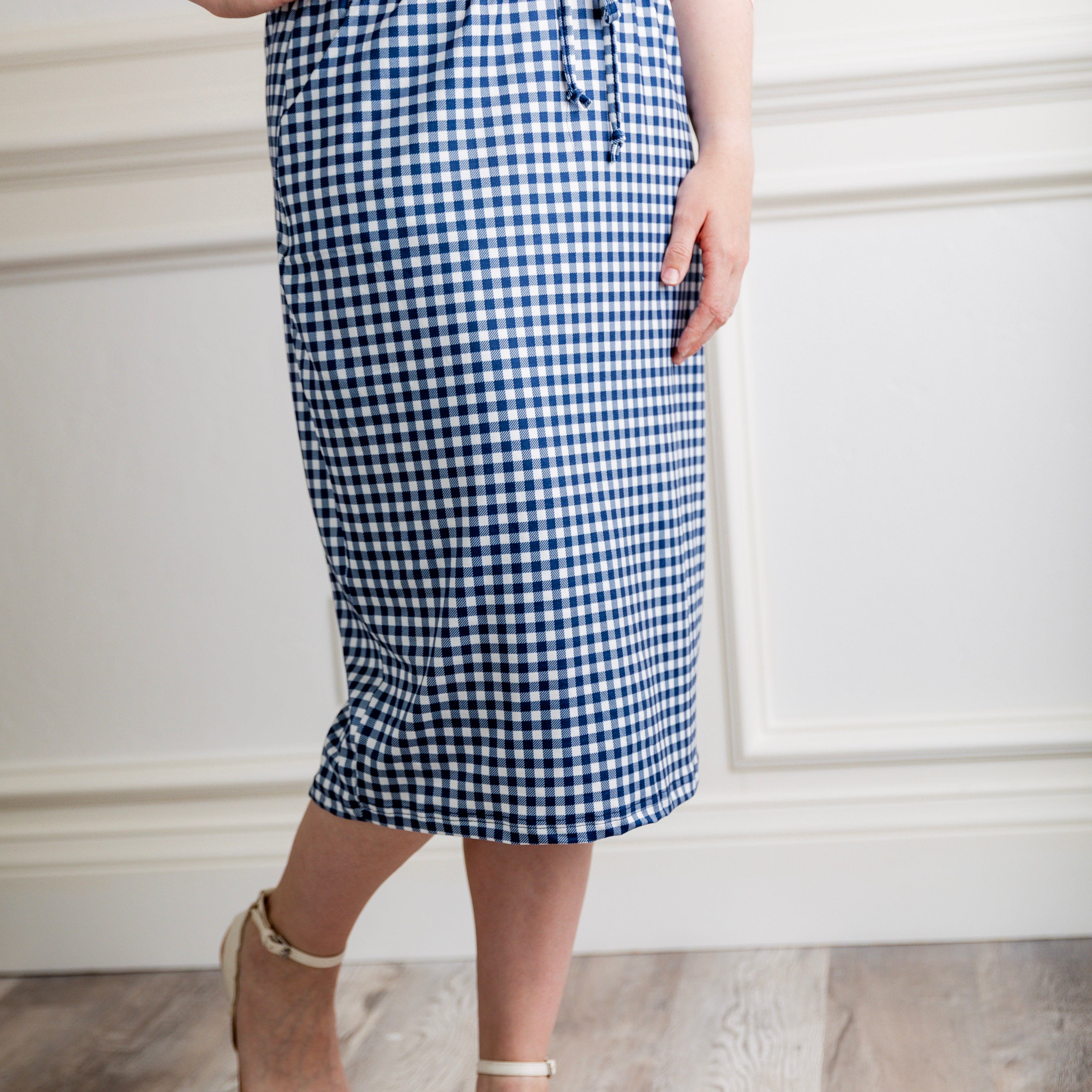 Woman in a modest 27-inch blue gingham knit skirt featuring side pockets and a drawstring waistband.